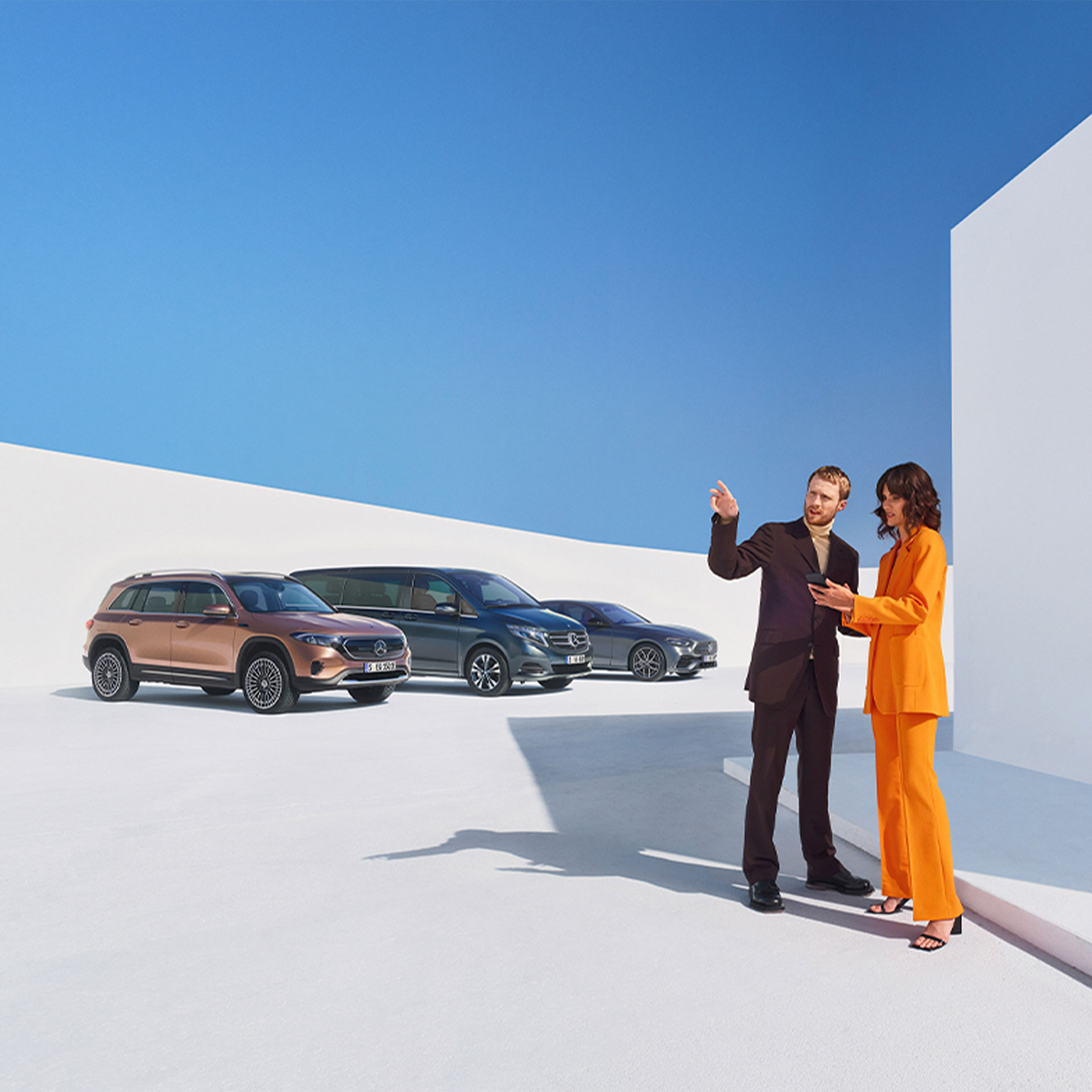 Digital Extras per clienti aziendali | Digital Extras | Mercedes-Benz Un uomo e una donna davanti ad alcuni veicoli Mercedes-Benz.