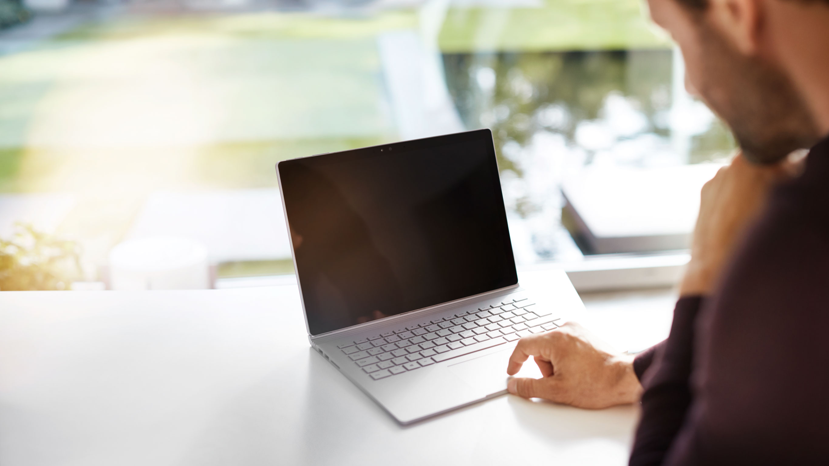 Lavoro efficiente con la tecnologia moderna Un primo piano di un computer portatile su una scrivania con una persona che si avvicina ad esso