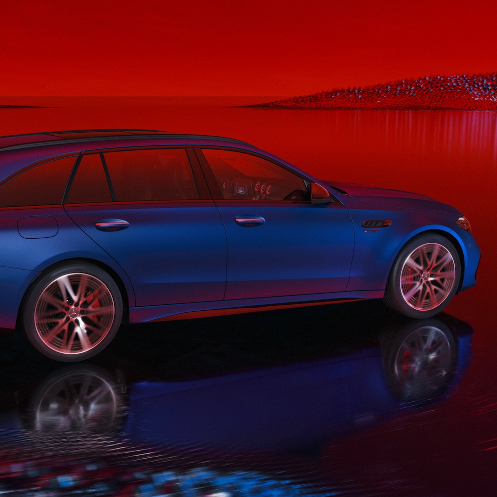 Mercedes-AMG C 63 S E PERFORMANCE station wagon con vernice blu spettrale magno MANUFAKTUR, vista laterale su sfondo rosso.