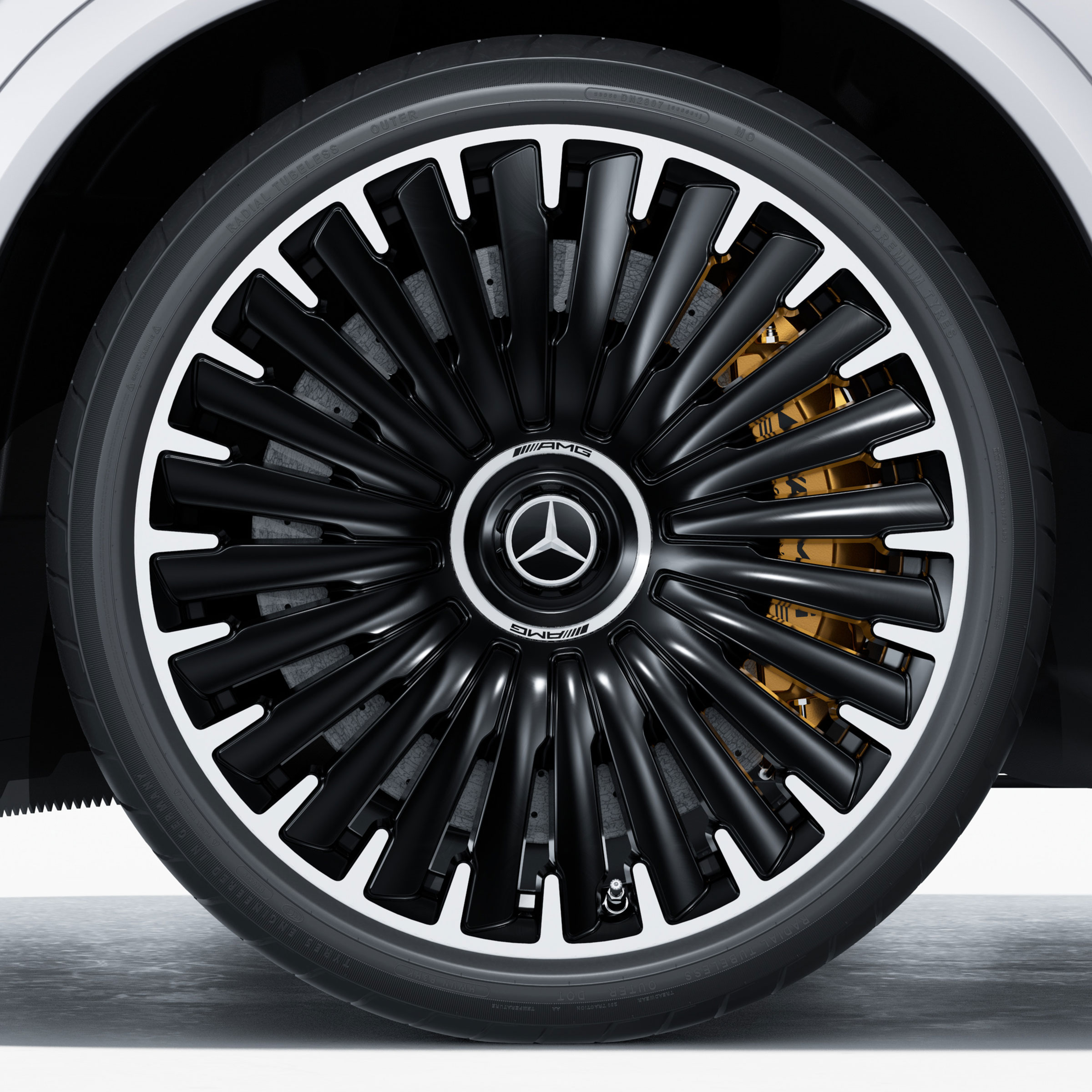 Primo piano di un cerchio in lega leggera AMG d cui si intravvede l'impianto frenante ceramico in materiale composito ad alte prestazioni AMG.