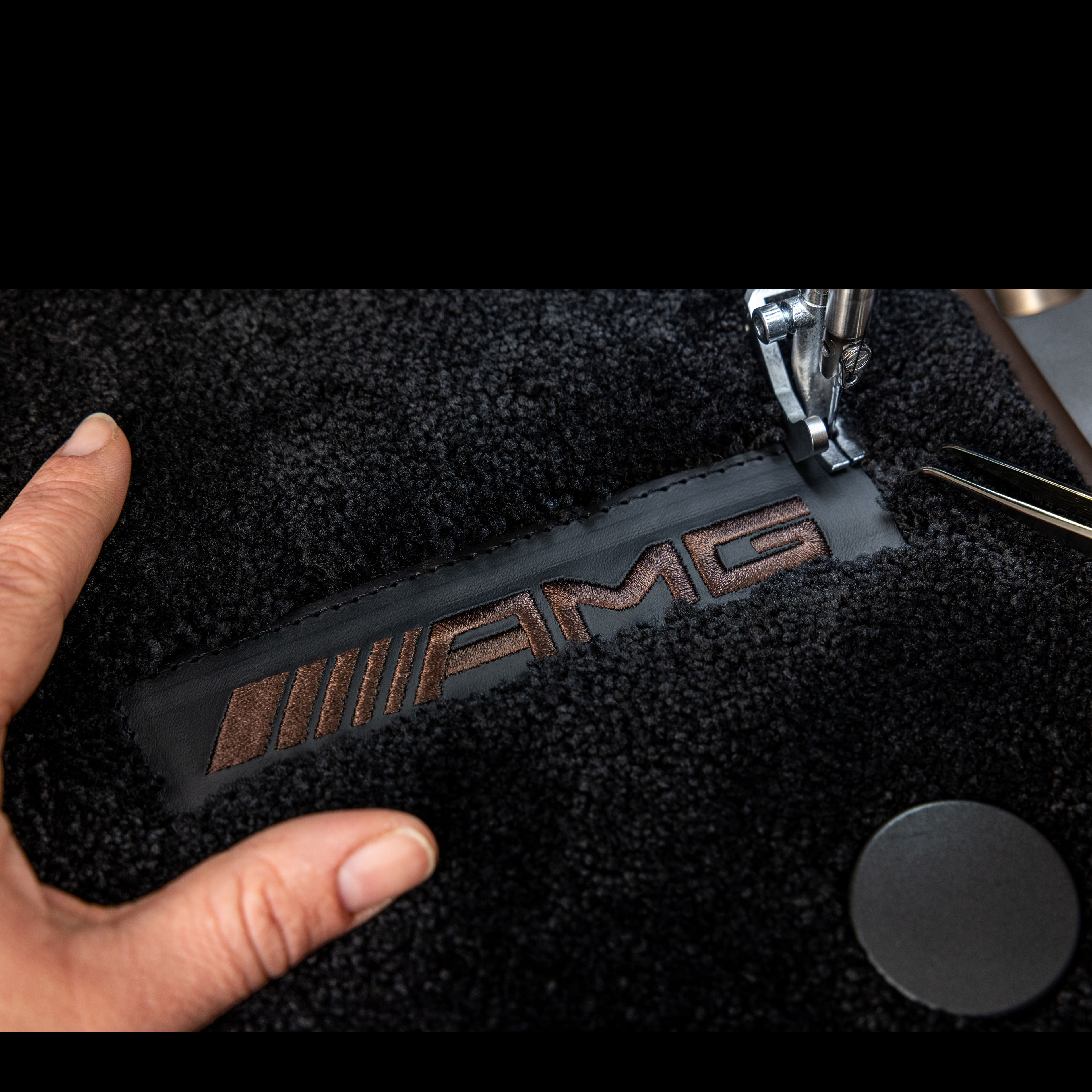 MANUFAKTUR | Mercedes-AMG Scritta MANUFAKTUR su una superficie scura di una Mercedes-AMG.