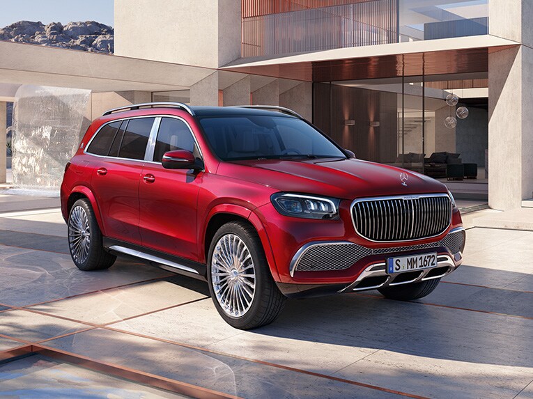 Vista anteriore di tre quarti di Mercedes-Maybach GLS davanti a una casa moderna