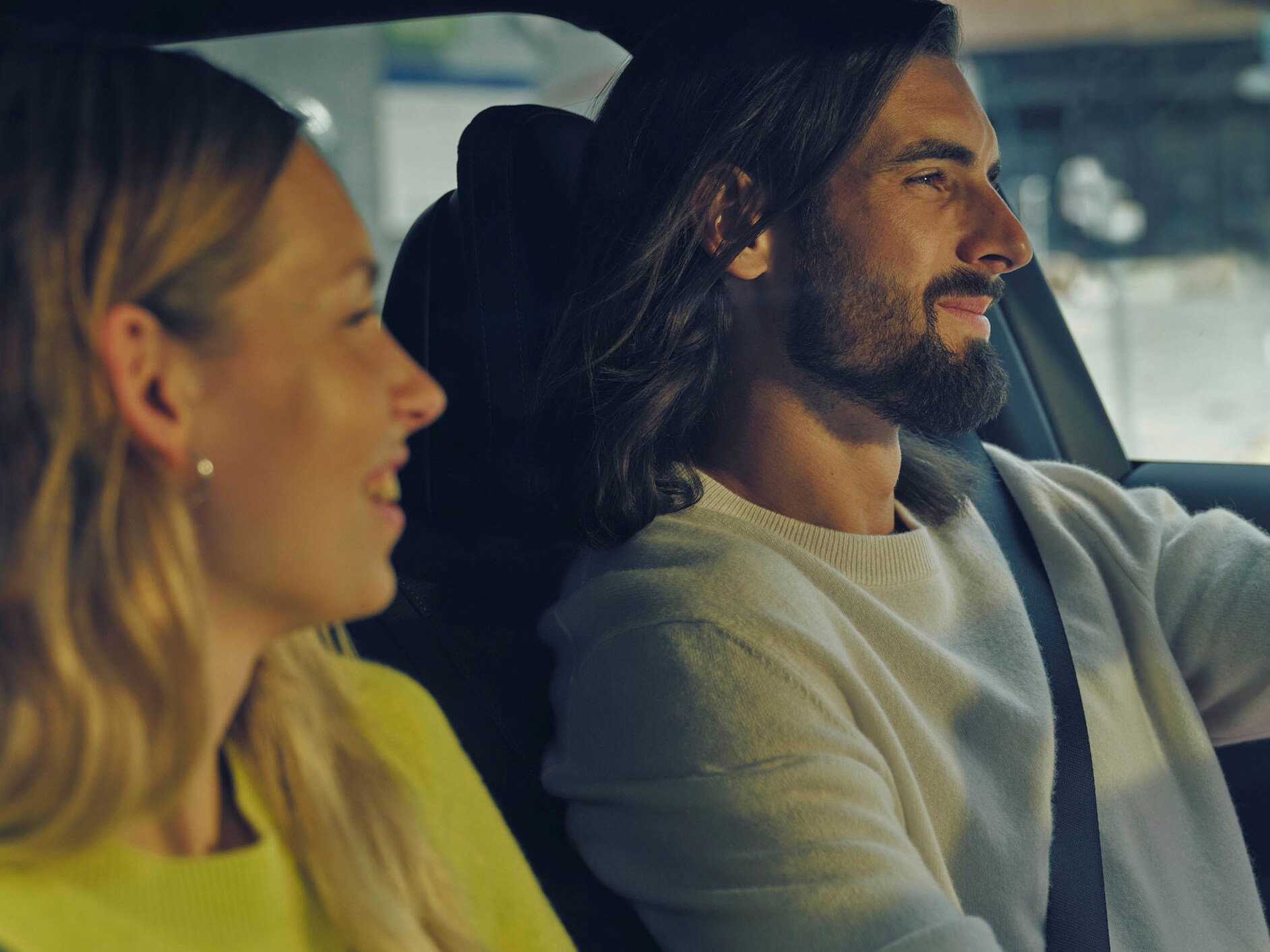 Due persone con un bambino davanti a un'auto Mercedes-Benz.