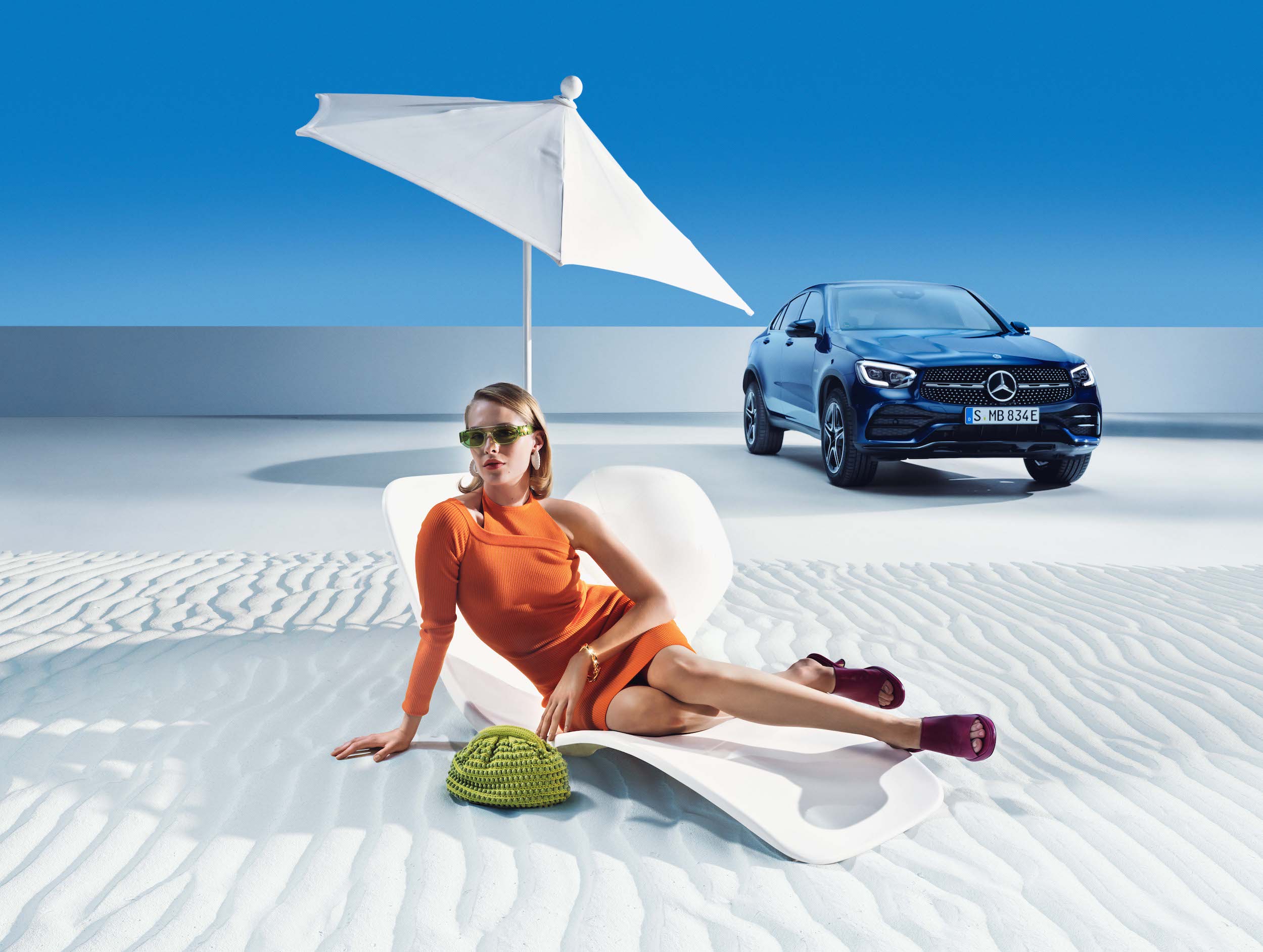 Mercedes-Benz | Prodotti originali per la pulizia Una donna sdraiata sulla spiaggia davanti alla sua Mercedes-Benz.