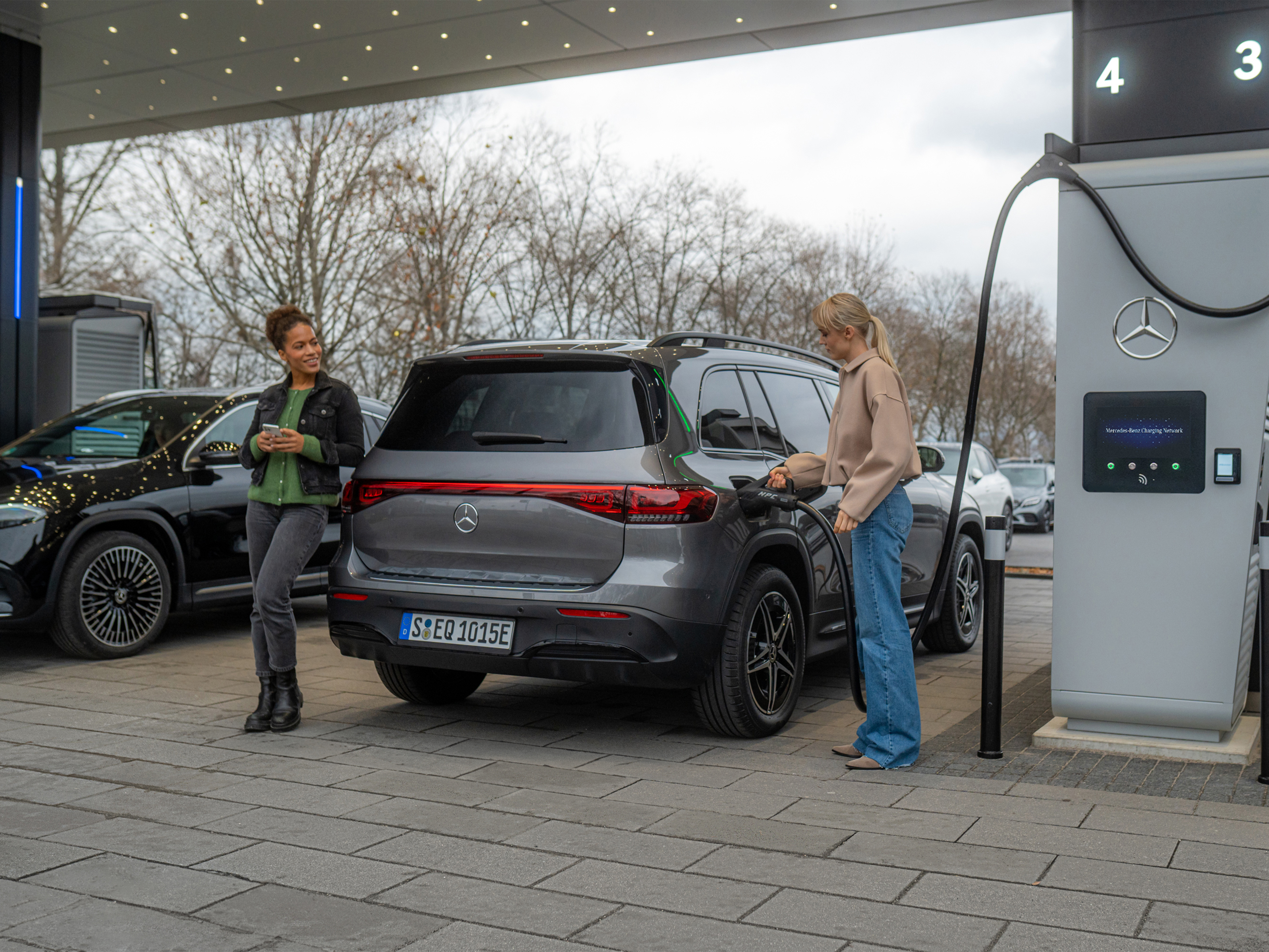 Rete di ricarica Mercedes-Benz | Ricarica in viaggio| Mercedes-Benz Due veicoli elettrici Mercedes-Benz presso una stazione di ricarica.