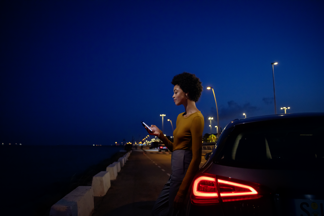 Manuali | Mercedes-Benz Donna appoggiata a una Mercedes-Benz con in mano uno smartphone