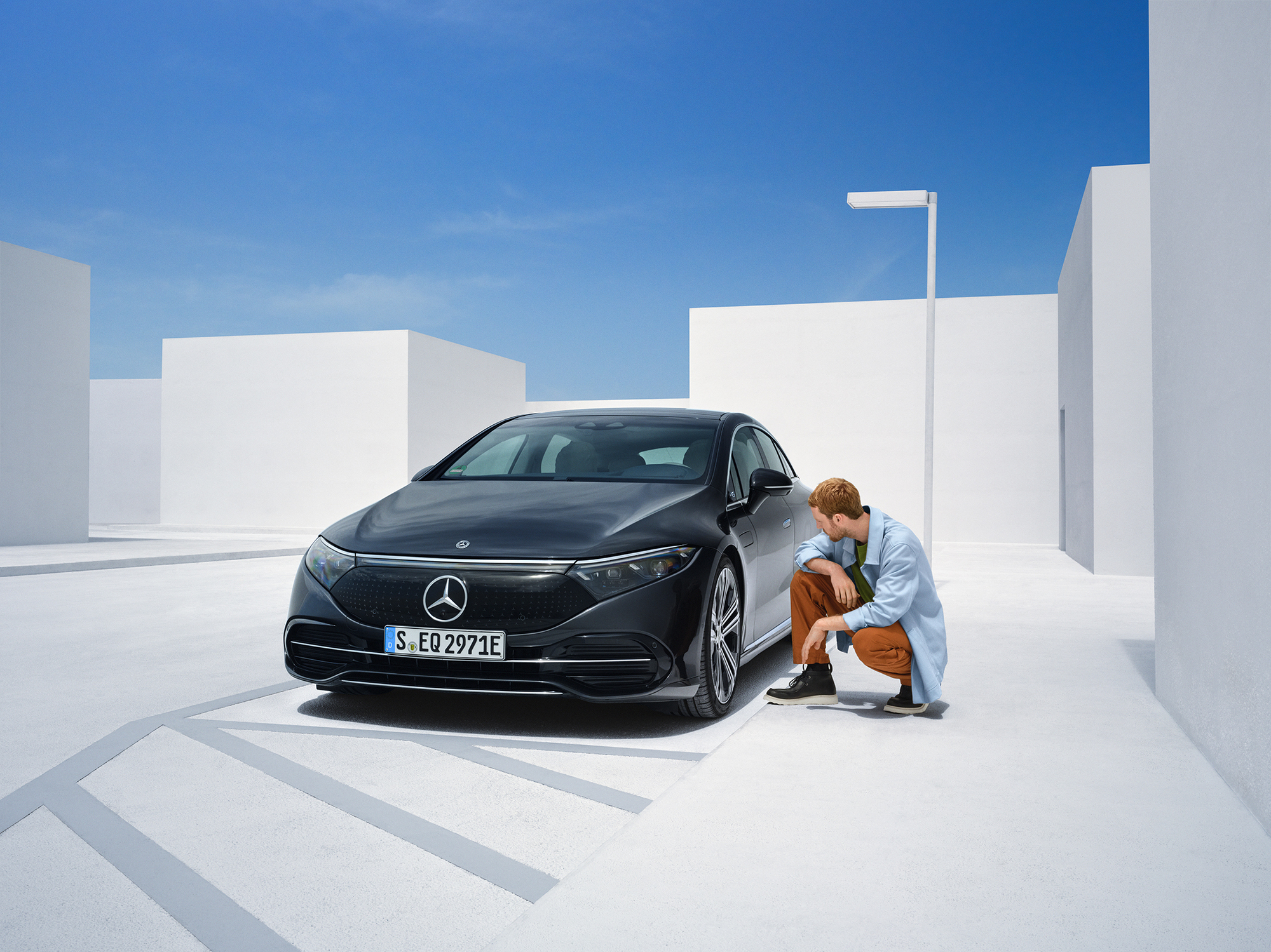 Danni da incidente | Mercedes-Benz Una persona è inginocchiata a lato della sua vettura Mercedes-Benz per controllarla.