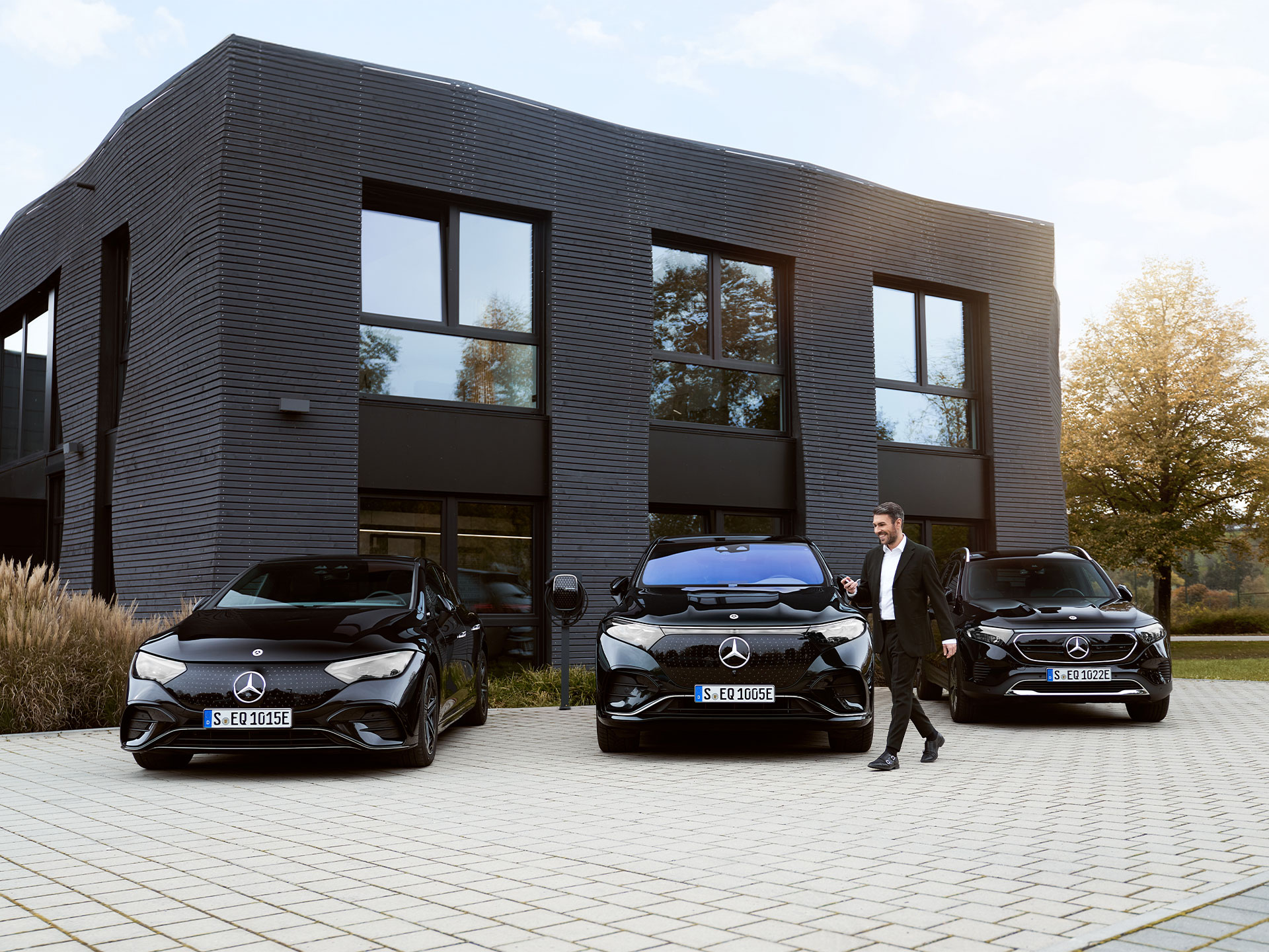 Ricarica in deposito | Ricarica | Mercedes-Benz Tre auto elettriche Mercedes-Benz davanti a un edificio che ospita degli uffici.