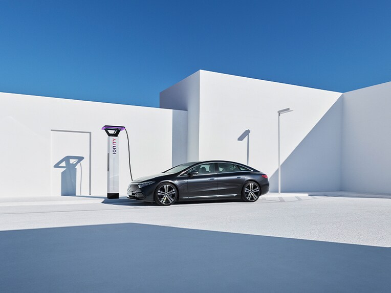 Una Mercedes-Benz EQS ferma presso una stazione di ricarica.