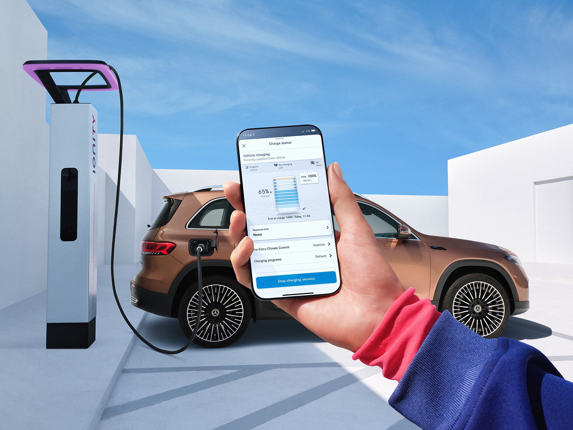 Una donna ricarica comodamente la sua Mercedes-Benz ad una stazione di ricarica IONITY.