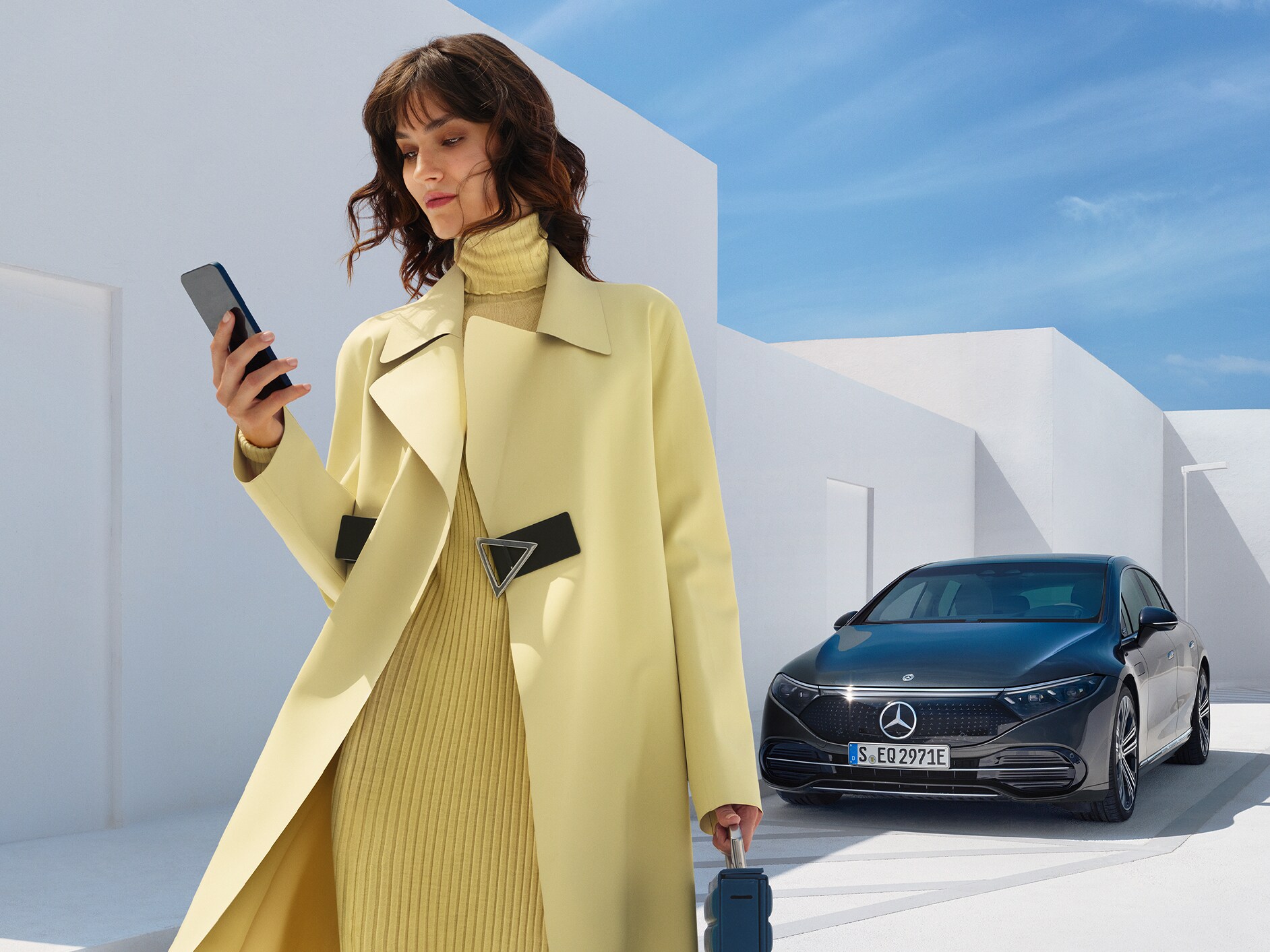 Una donna di fronte all'EQS Berlina di Mercedes-Benz.