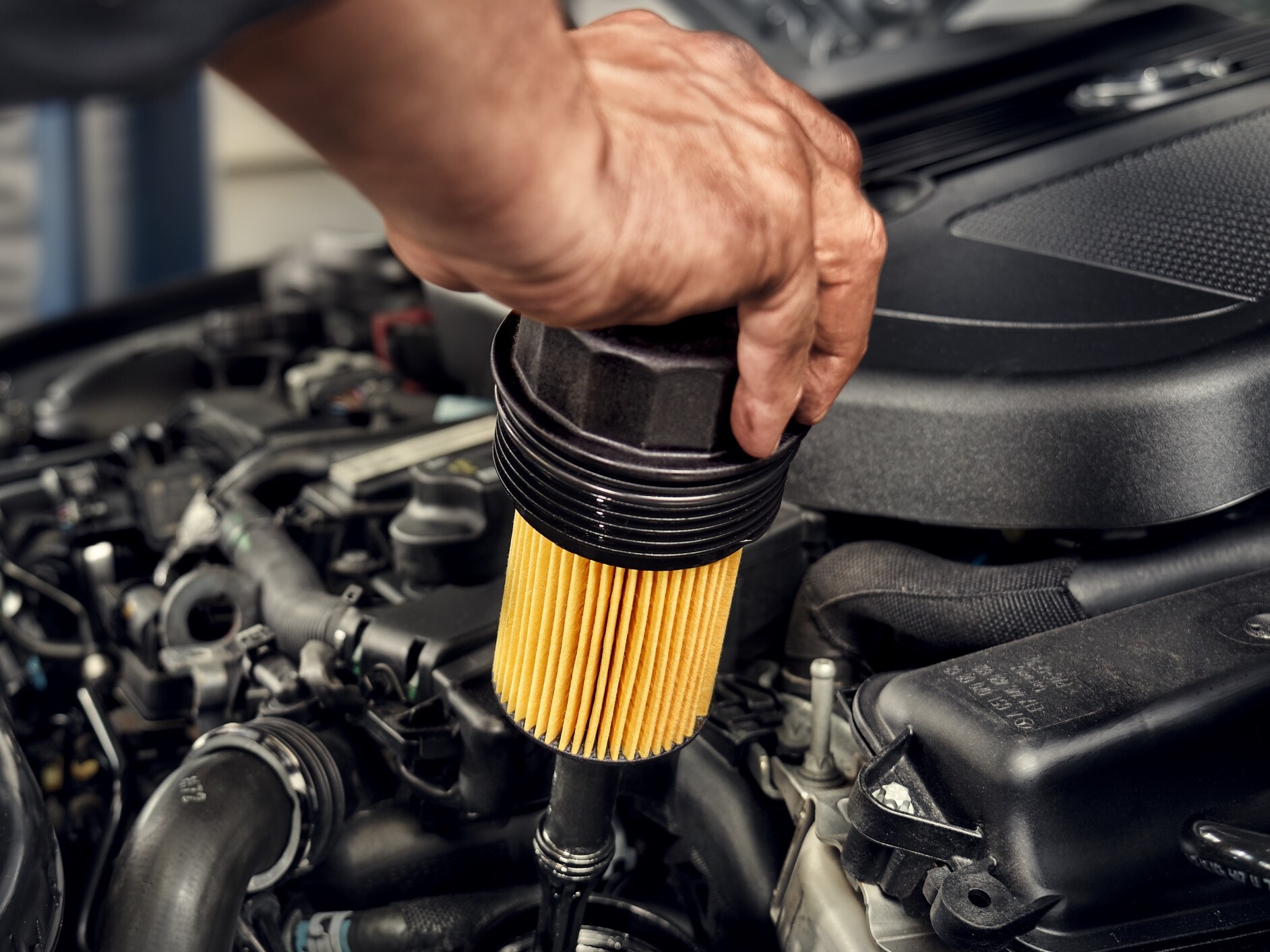 Un tecnico mentre installa il filtro dell'olio su un veicolo Mercedes-Benz.