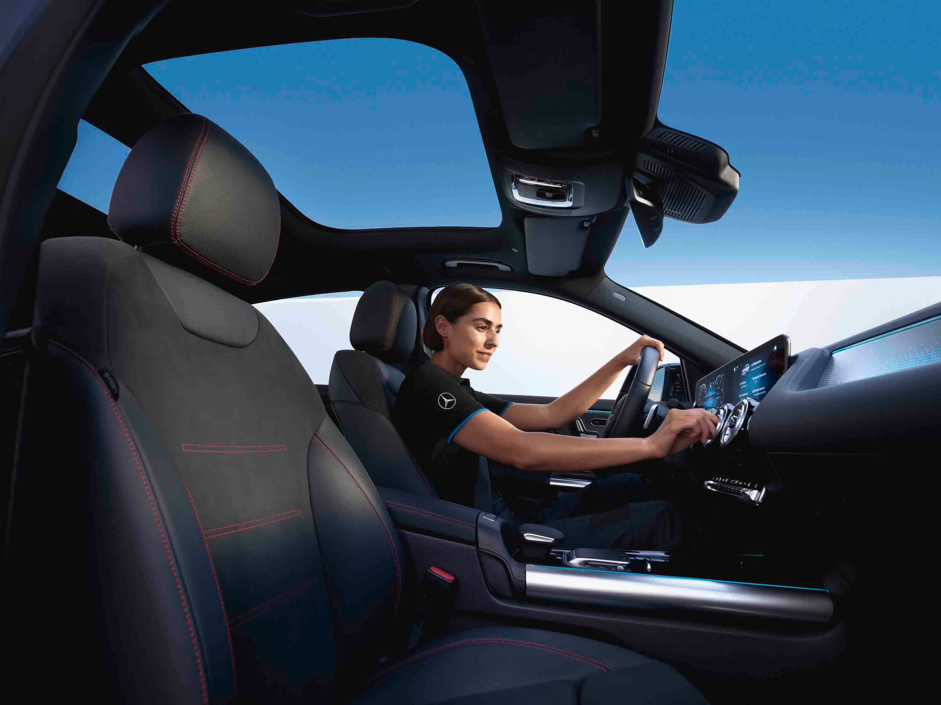 Un meccanico sedutoin una vettura Mercedes-Benz controlla il filtro dell'aria dell'abitacolo.