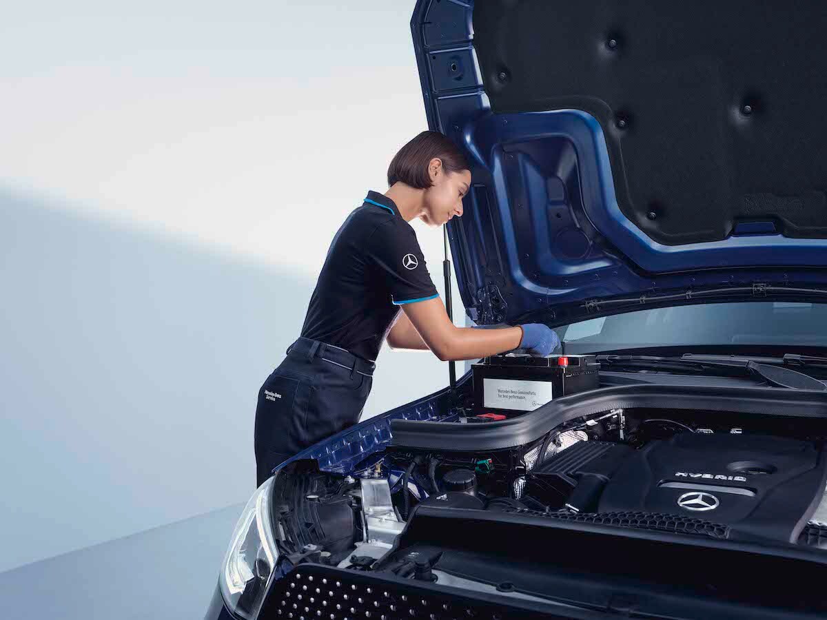 Un tecnico Mercedes-Benz esamina la batteria di un'auto.