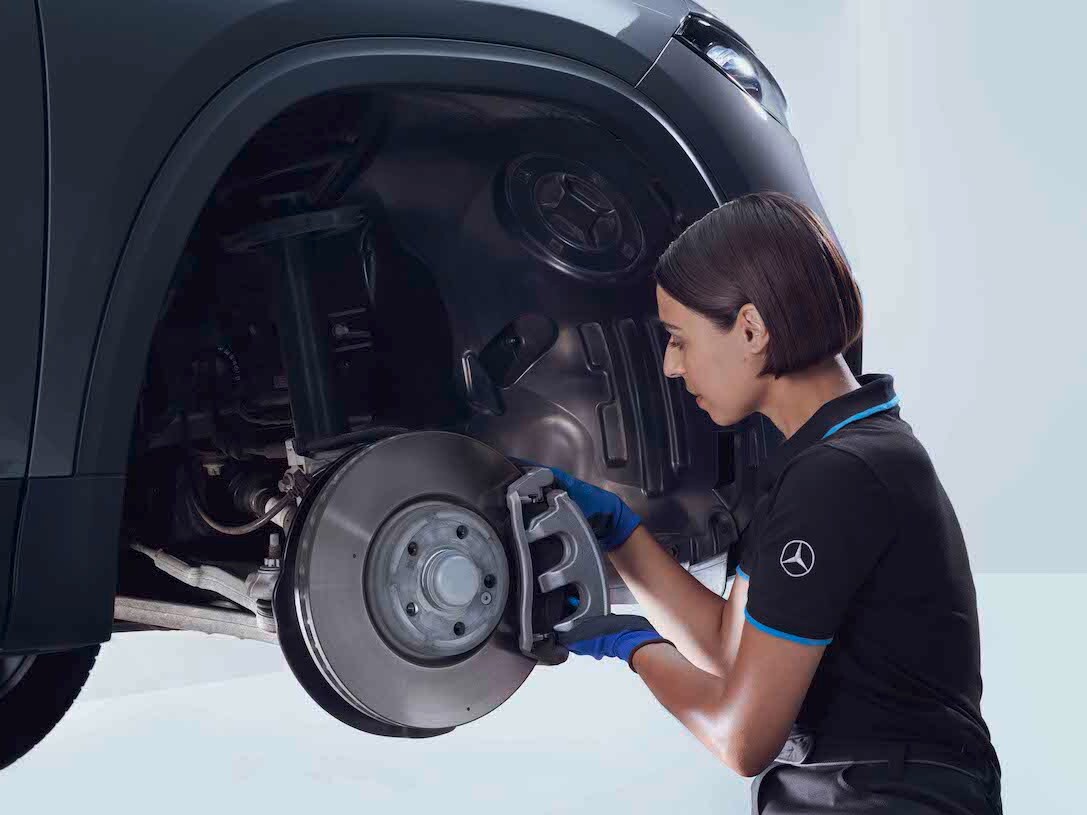Un tecnico Mercedes-Benz esamina i freni di un'auto.