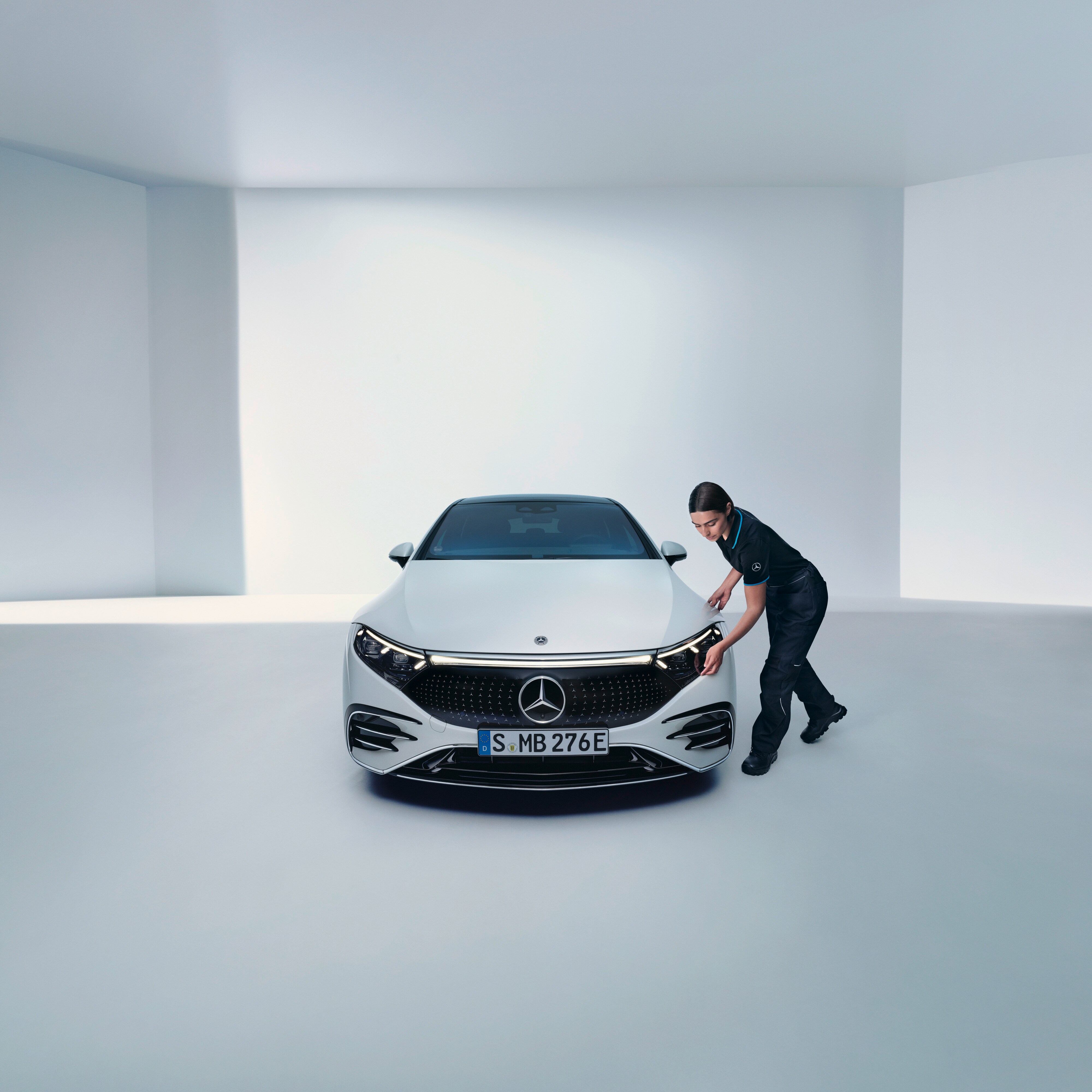 Un tecnico Mercedes-Benz esamina un faro di una vettura Mercedes-Benz.