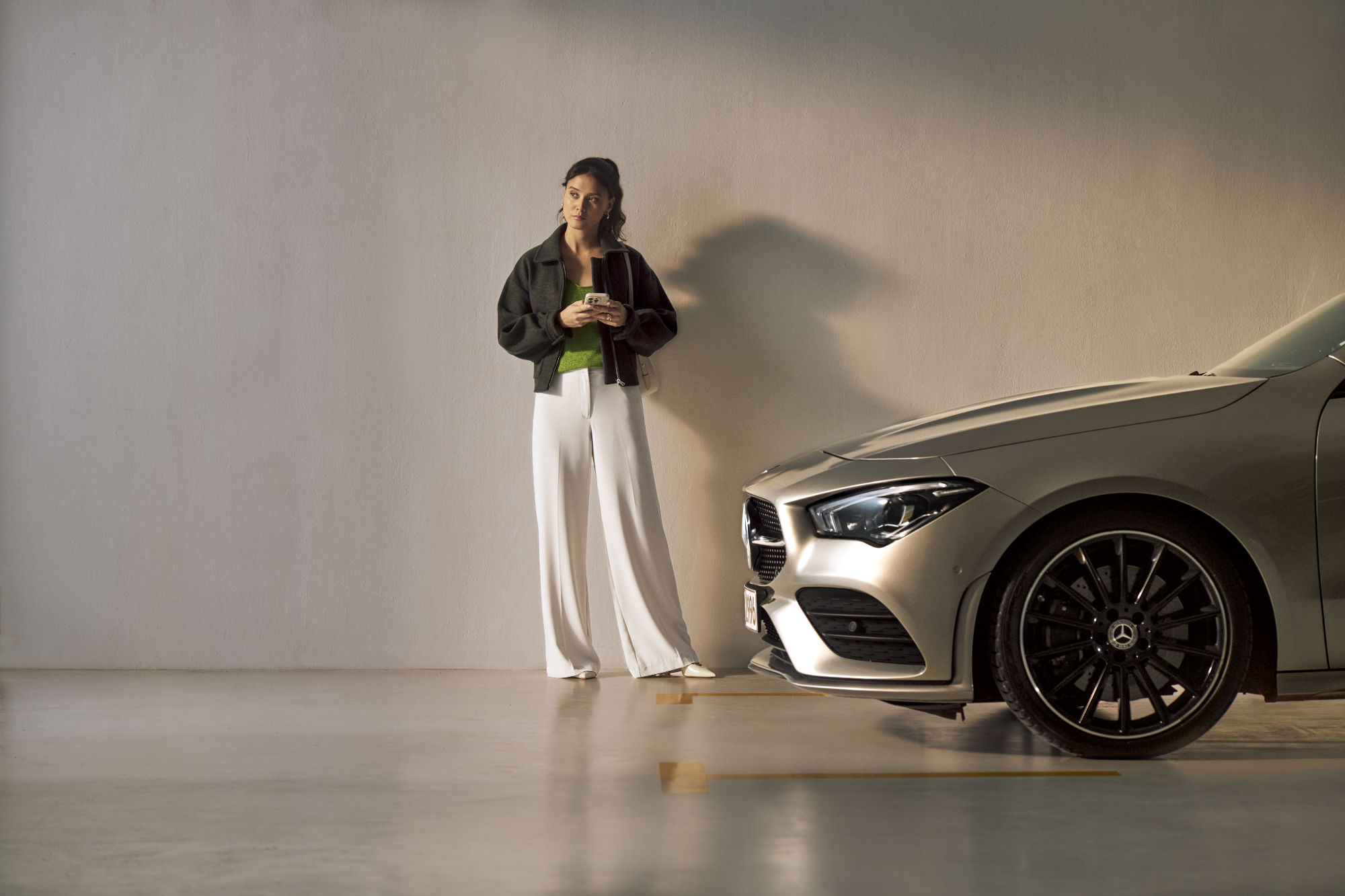 Servizio assistenza Select | Mercedes-Benz Una persona davanti a un veicolo Mercedes-Benz.