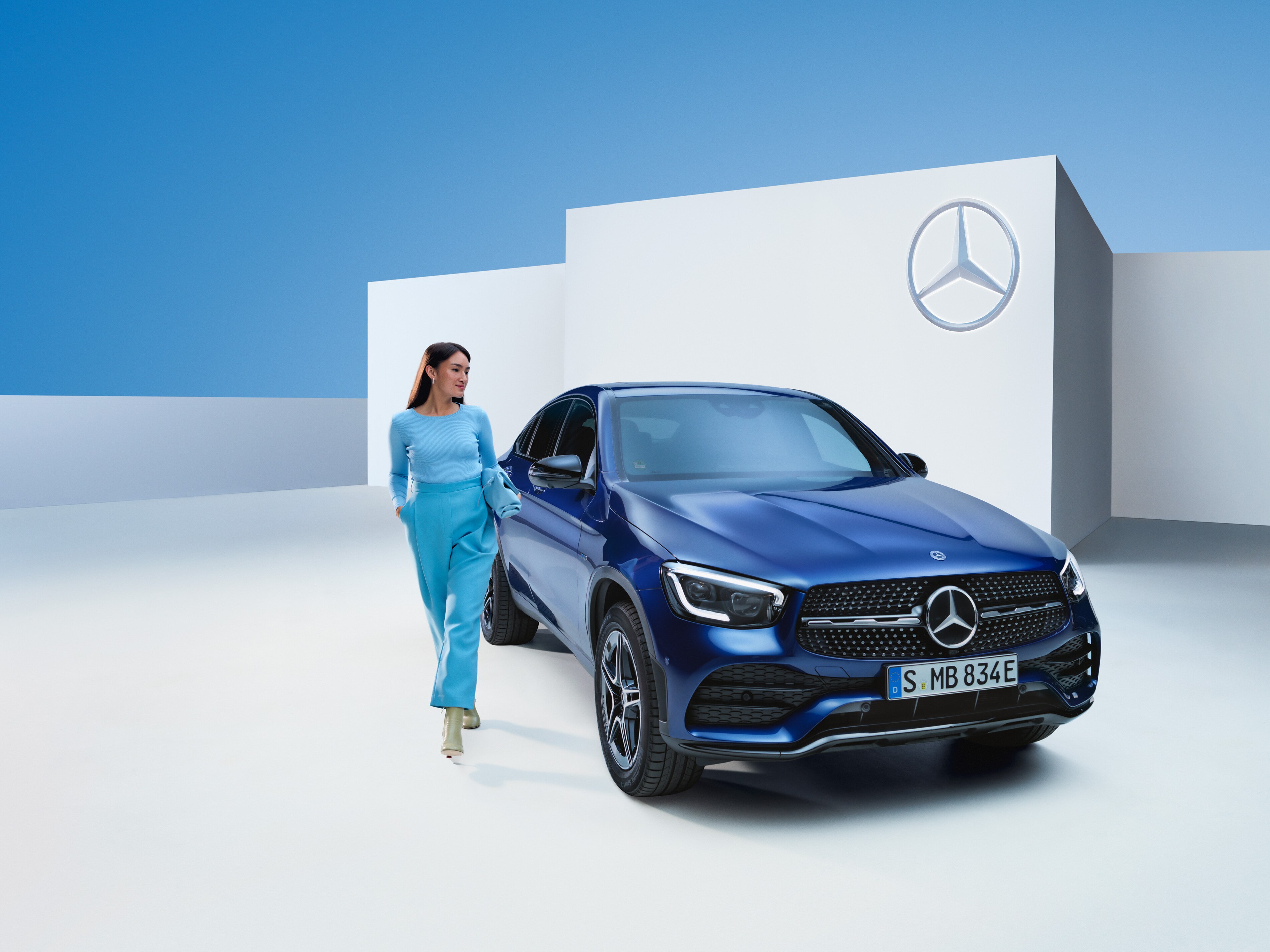 Una donna cammina accanto alla sua Mercedes-Benz.