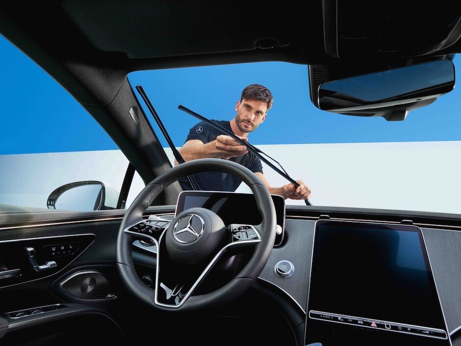 Un tecnico Mercedes-Benz mentre sostituisce i tergicristalli di un'auto.