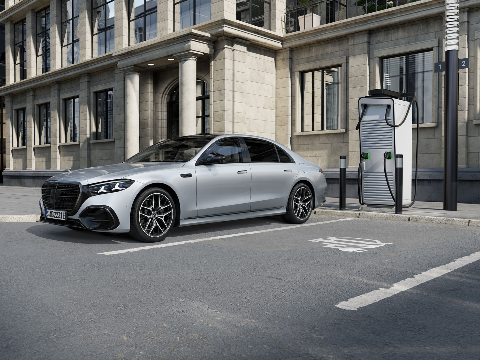 Incentivi | Modelli ibridi plug-in | Mercedes-Benz La Mercedes-Benz Classe S Berlina Long ibrida plug-in in una vista laterale sette-ottavi, parcheggiata in un parcheggio accanto a una stazione di ricarica.