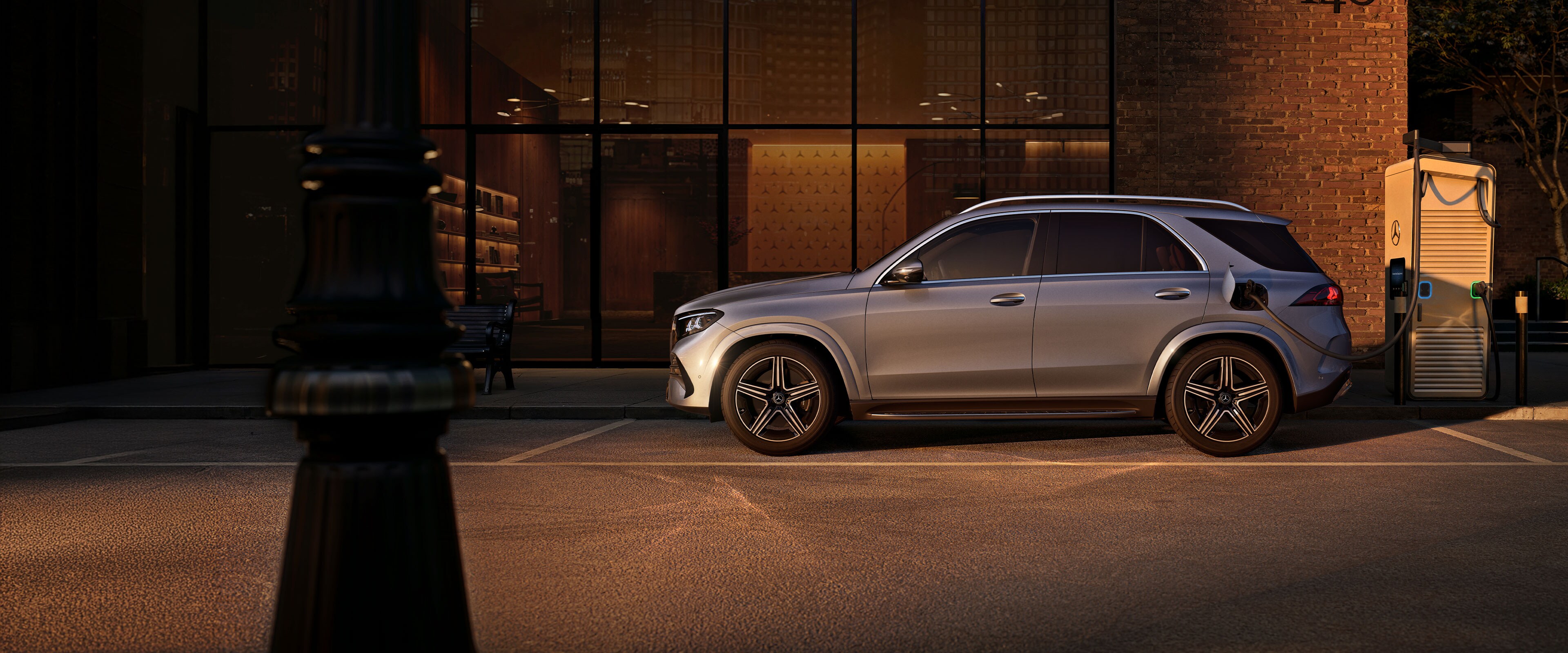 La Mercedes-Benz GLE SUV in una foto laterale davanti a una grande casa.