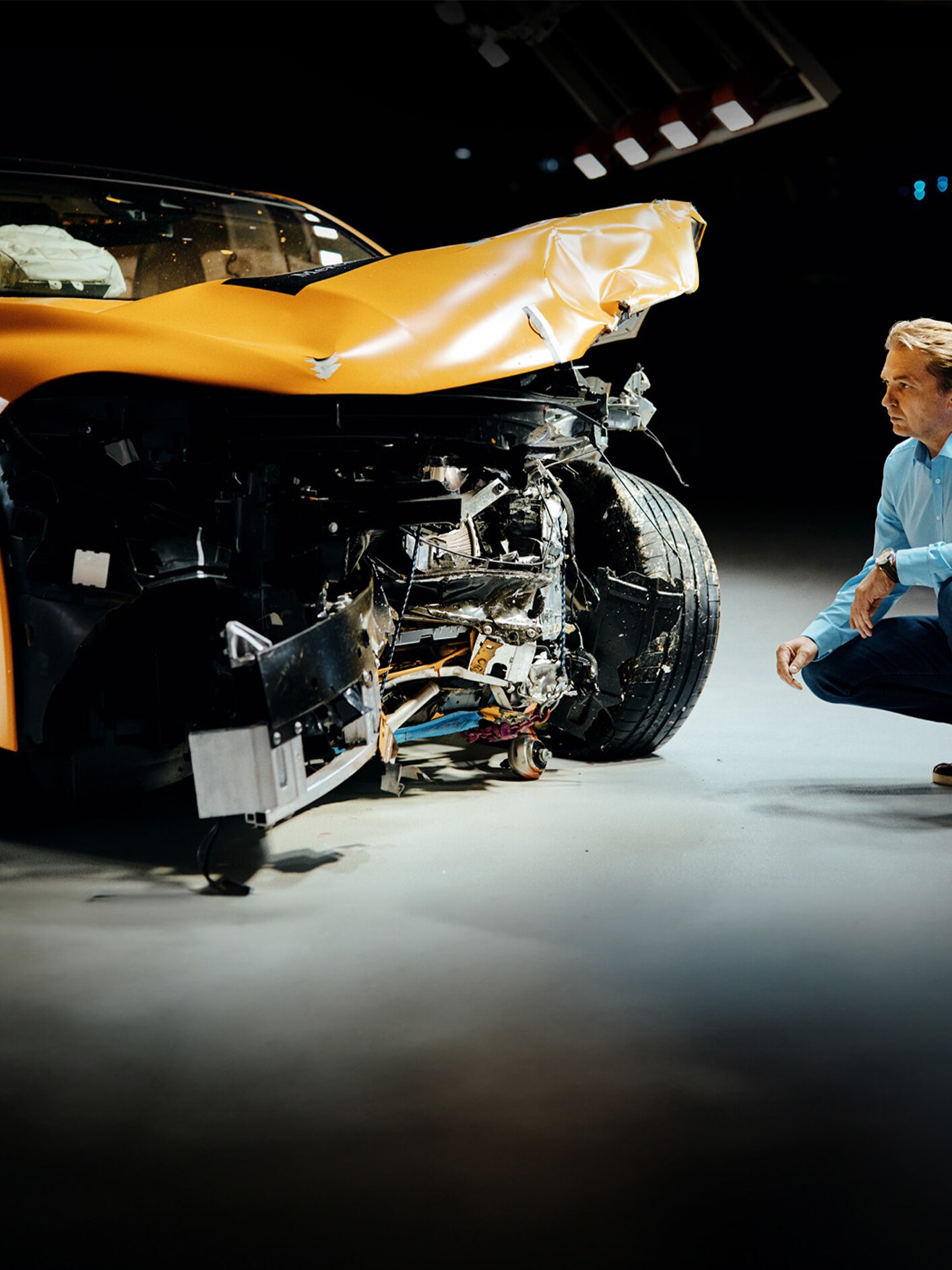 Un esperto di crash test mentre esamina una Mercedes-Benz incidentata sul frontale