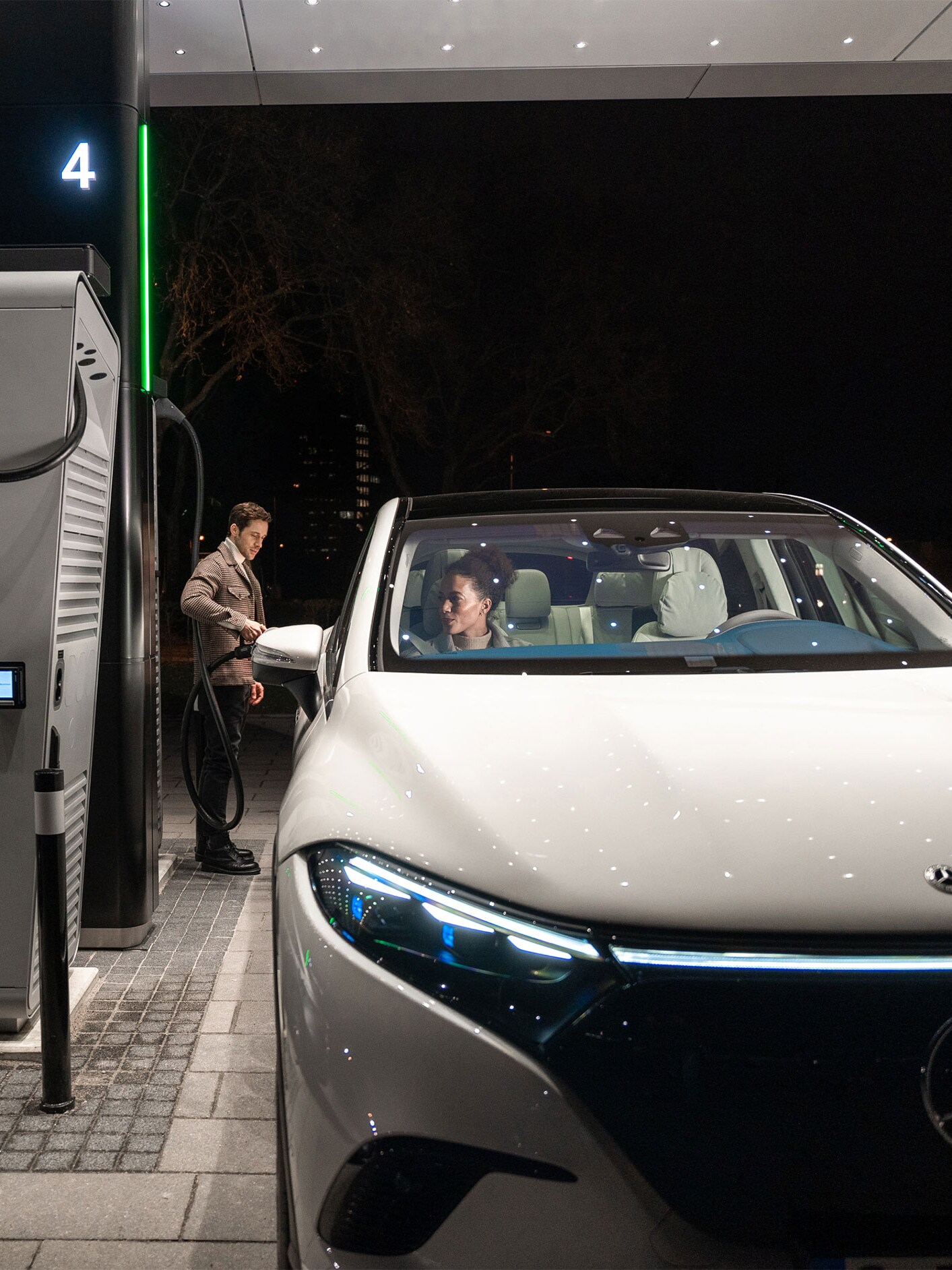 Mercedes-Benz CLA elettrica ferma su una strada e collegata a una stazione di ricarica.