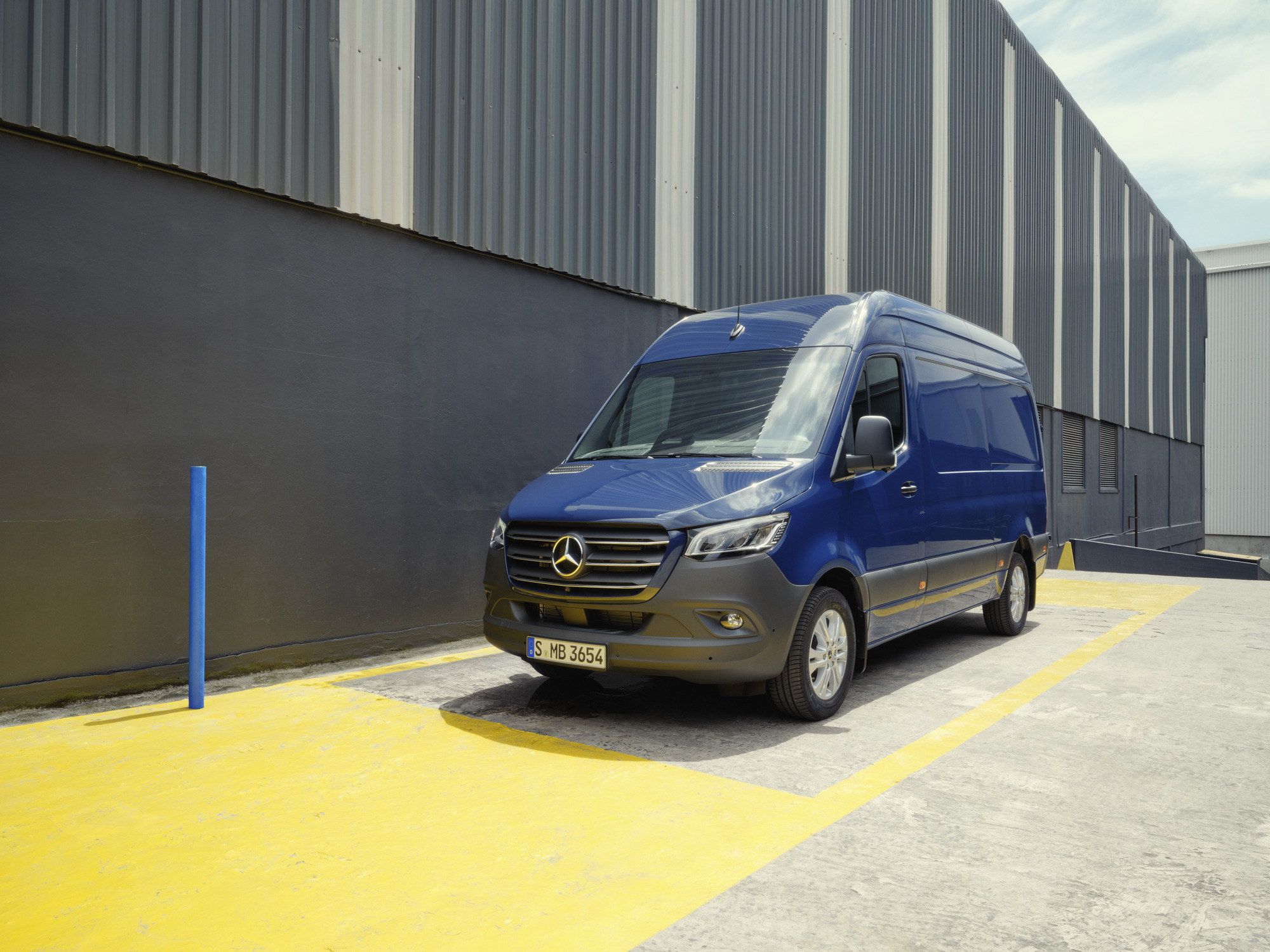 La versatilità del veicolo commerciale Mercedes-Benz Sprinter Un veicolo commerciale Mercedes-Benz Sprinter blu parcheggiato presso un edificio industriale
