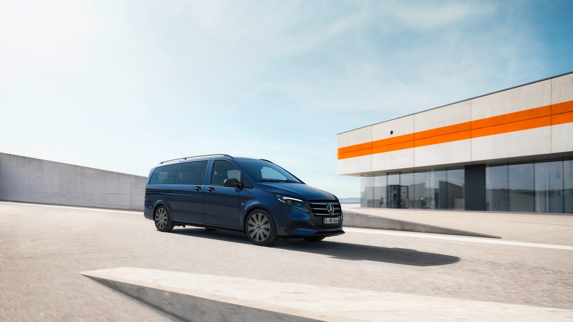 In veicolo commerciale Mercedes-Benz Classe V mentre passa davanti a un edificio moderno