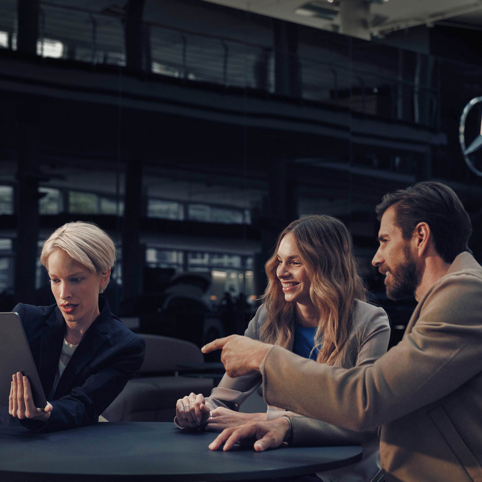 Veicoli usati | Leasing & finanziamento | Financial Services | Mercedes-Benz Un uomo e una donna seduto a un tavolo con un concessionario Mercedes-Benz