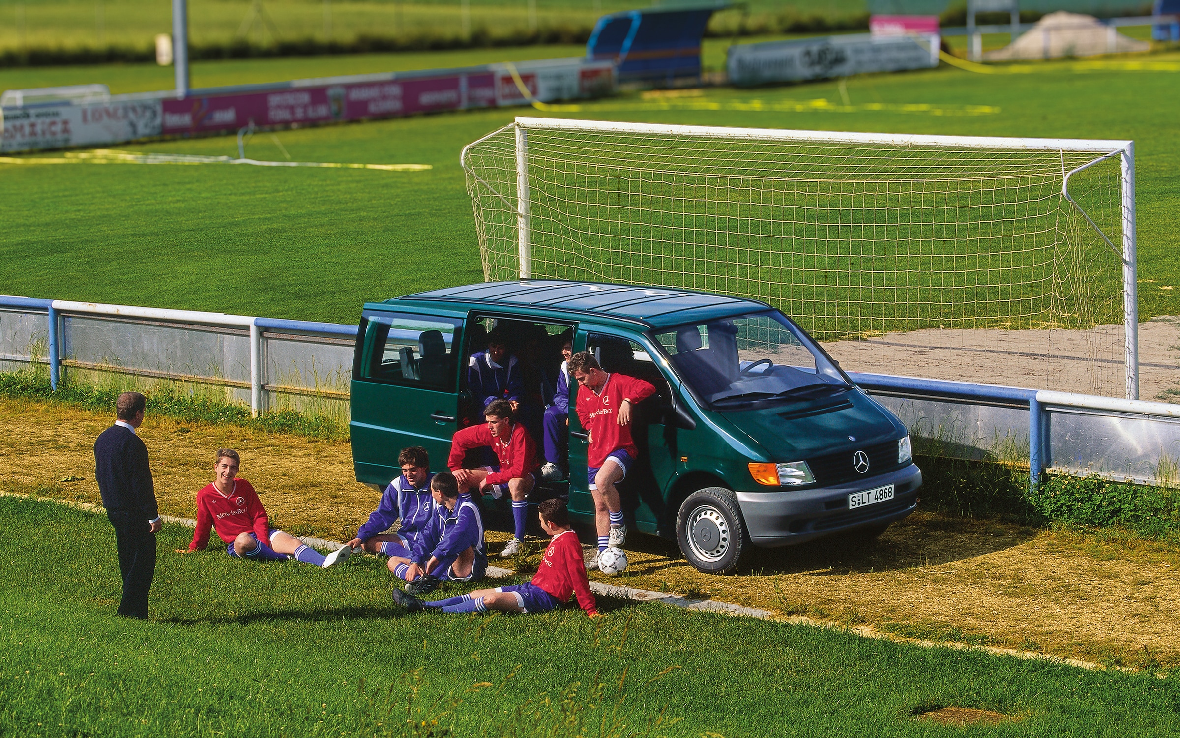 La prima generazione del Mercedes-Benz Vito | Storia dei veicoli commerciali | Mercedes-Benz Un Vito di prima generazione parcheggiato accanto a un campo da calcio, con i giocatori della squadra nelle vicinanze