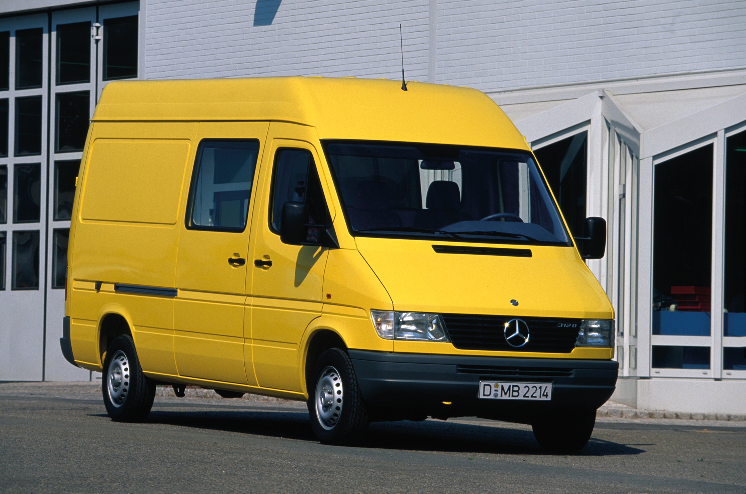 La prima generazione di Mercedes-Benz Sprinter | Storia dei veicoli commerciali | Mercedes-Benz Uno Sprinter di prima generazione parcheggiato davanti a un capannone industriale