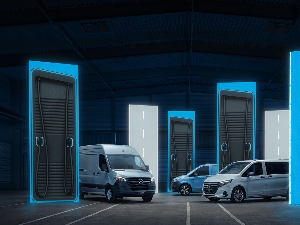 Veicoli commerciali elettrici Mercedes-Benz con soluzioni per la ricarica intelligenti in un ambiente logistico all’avanguardia.