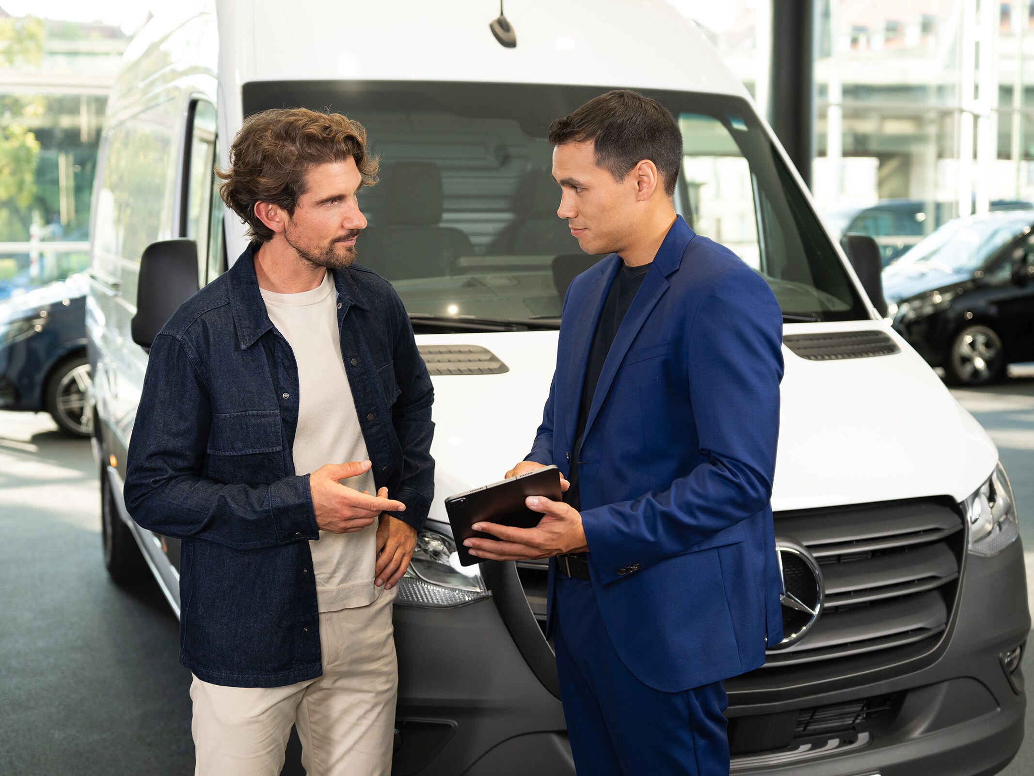 Consulenza sui veicoli commerciali Mercedes-Benz presso uno showroom, con particolare attenzione al servizio assistenza orientato al cliente.