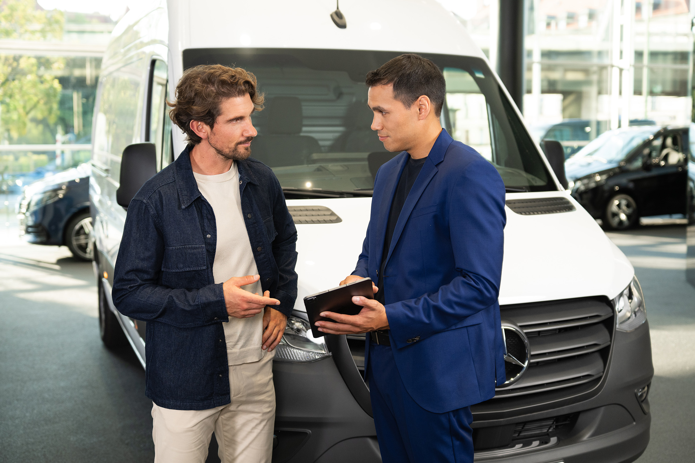 Leasing finanziario | Modelli elettrici | Mercedes-Benz Consulenza sui veicoli commerciali Mercedes-Benz presso uno showroom, con particolare attenzione al servizio assistenza orientato al cliente.