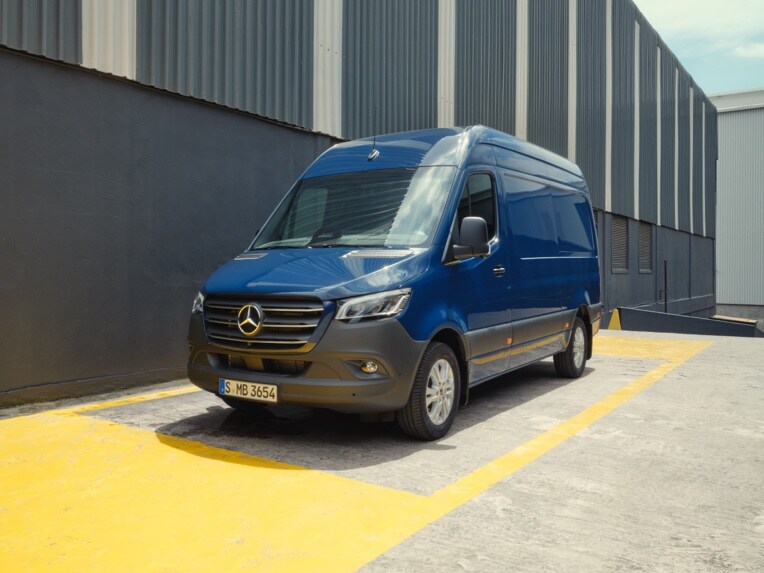 Un Mercedes-Benz Sprinter Furgone parcheggiato di fronte a materiali da costruzione.