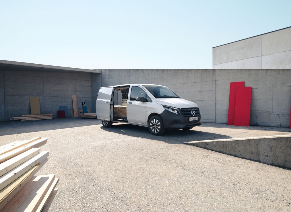 Vito Furgone in un'area industriale con la porta scorrevole lato guida aperta.