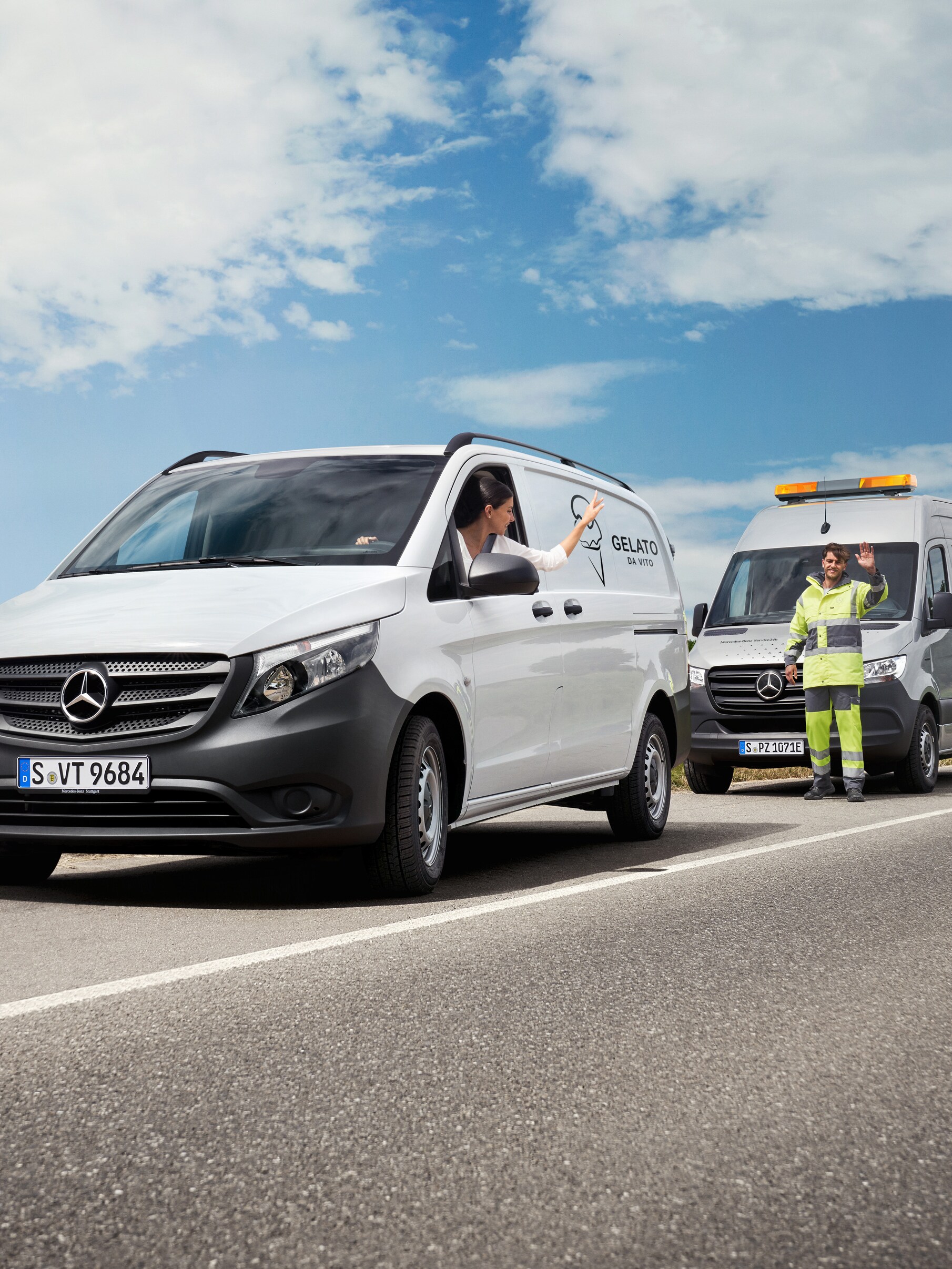 Il servizio assistenza Mercedes-Benz aiuta il conducente di un veicolo commerciale collocato sul bordo della strada, entrambi salutano in modo amichevole.