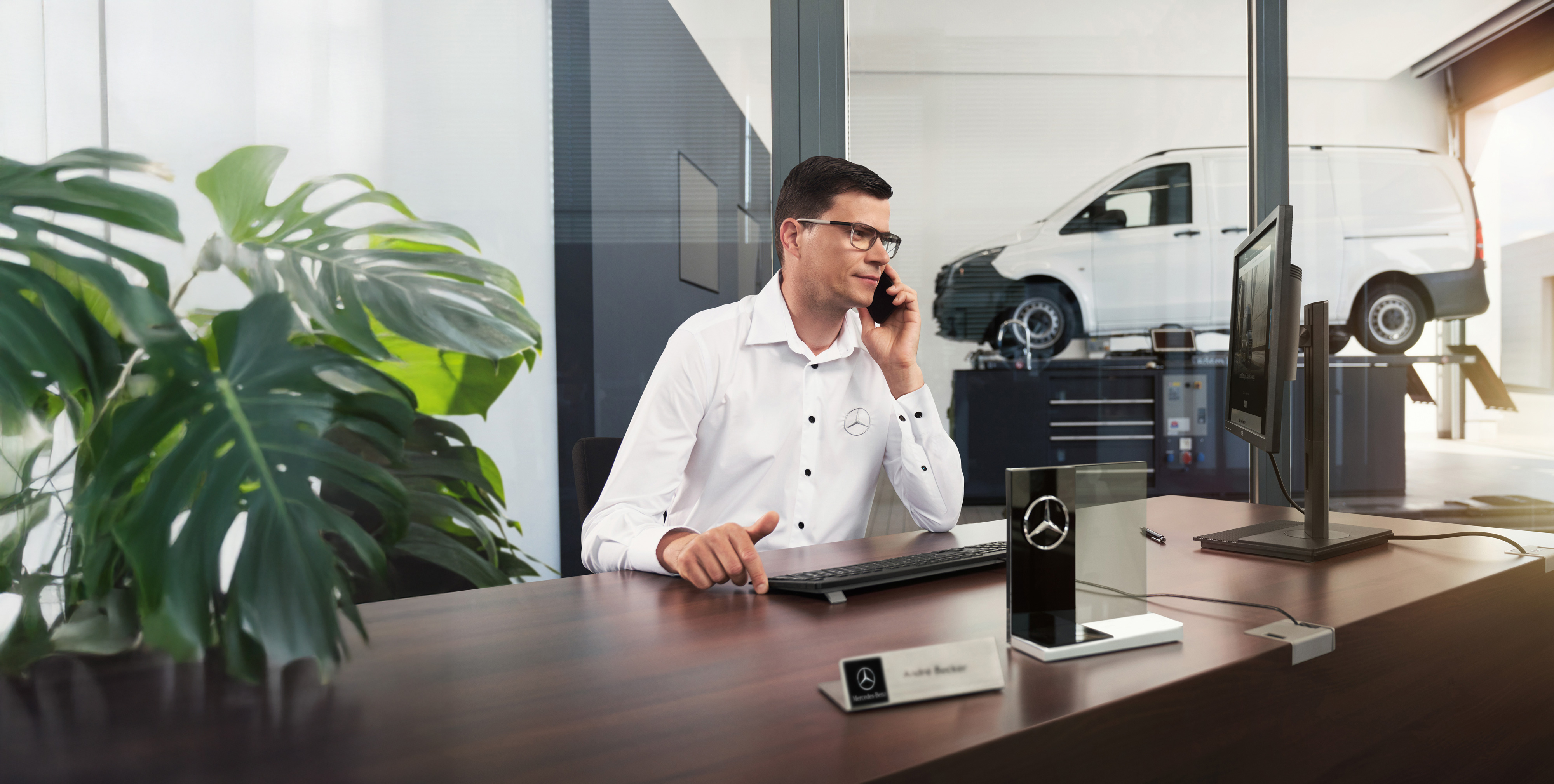 Mercedes-Benz | Assistenza veicoli commerciali Un dipendente Mercedes-Benz mentre parla al telefono