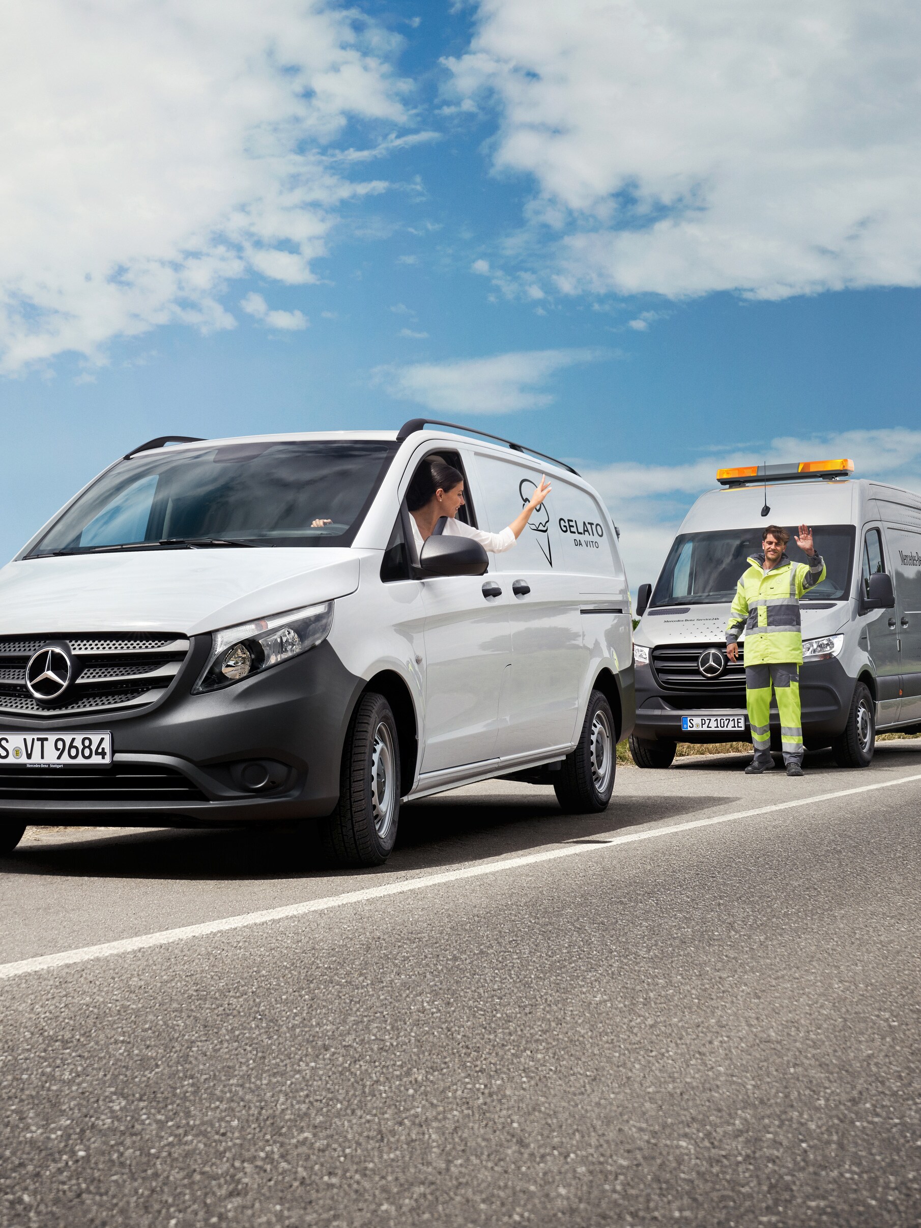 Una persona a bordo di un veicolo commerciale Mercedes-Benz Vito bianco saluta un tecnico del servizio assistenza parcheggiato sul bordo della strada.
