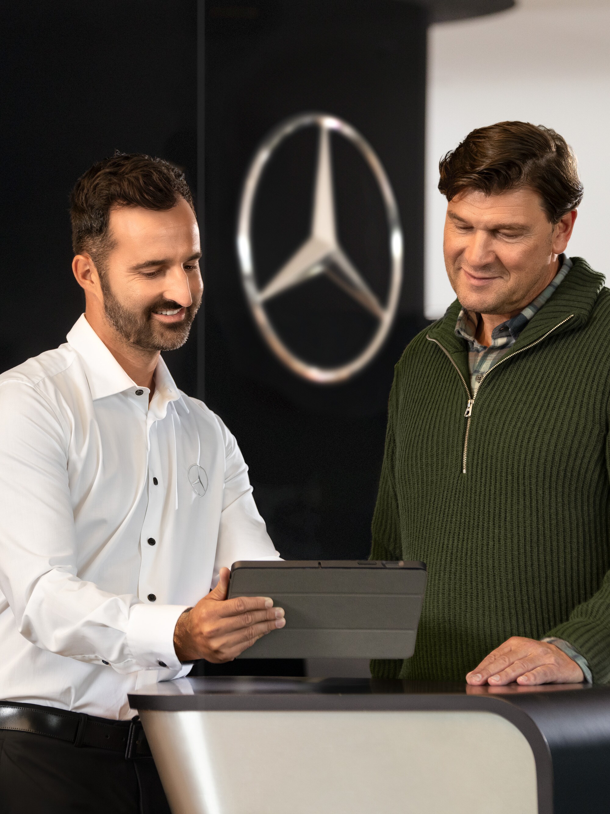 Un dipendente Mercedes consiglia i clienti al banco con un tablet