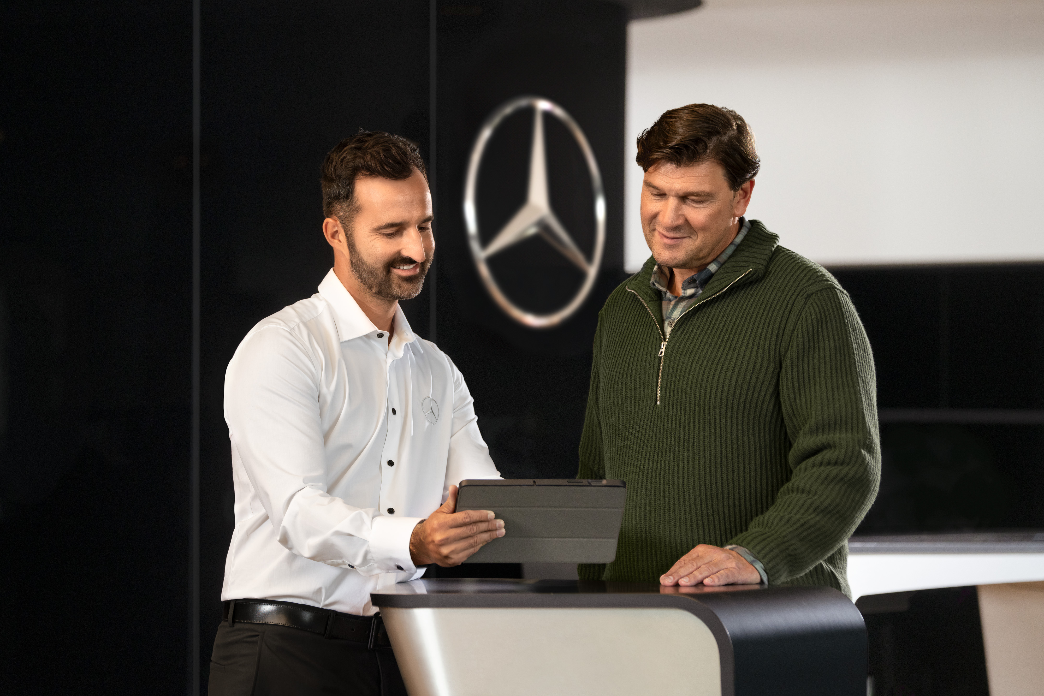 Mercedes-Benz | Assistenza veicoli commerciali | Assistenza personalizzata Un dipendente Mercedes consiglia i clienti al banco con un tablet