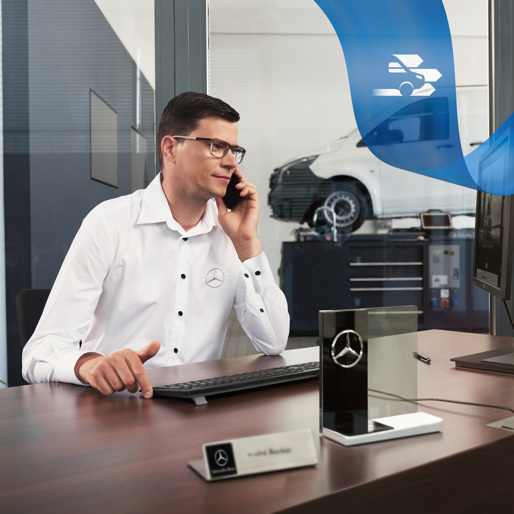 Mercedes-Benz | Assistenza veicoli commerciali | Soccorso stradale Un dipendente al telefono e sullo sfondo un veicolo commerciale Mercedes-Benz Vito in officina.