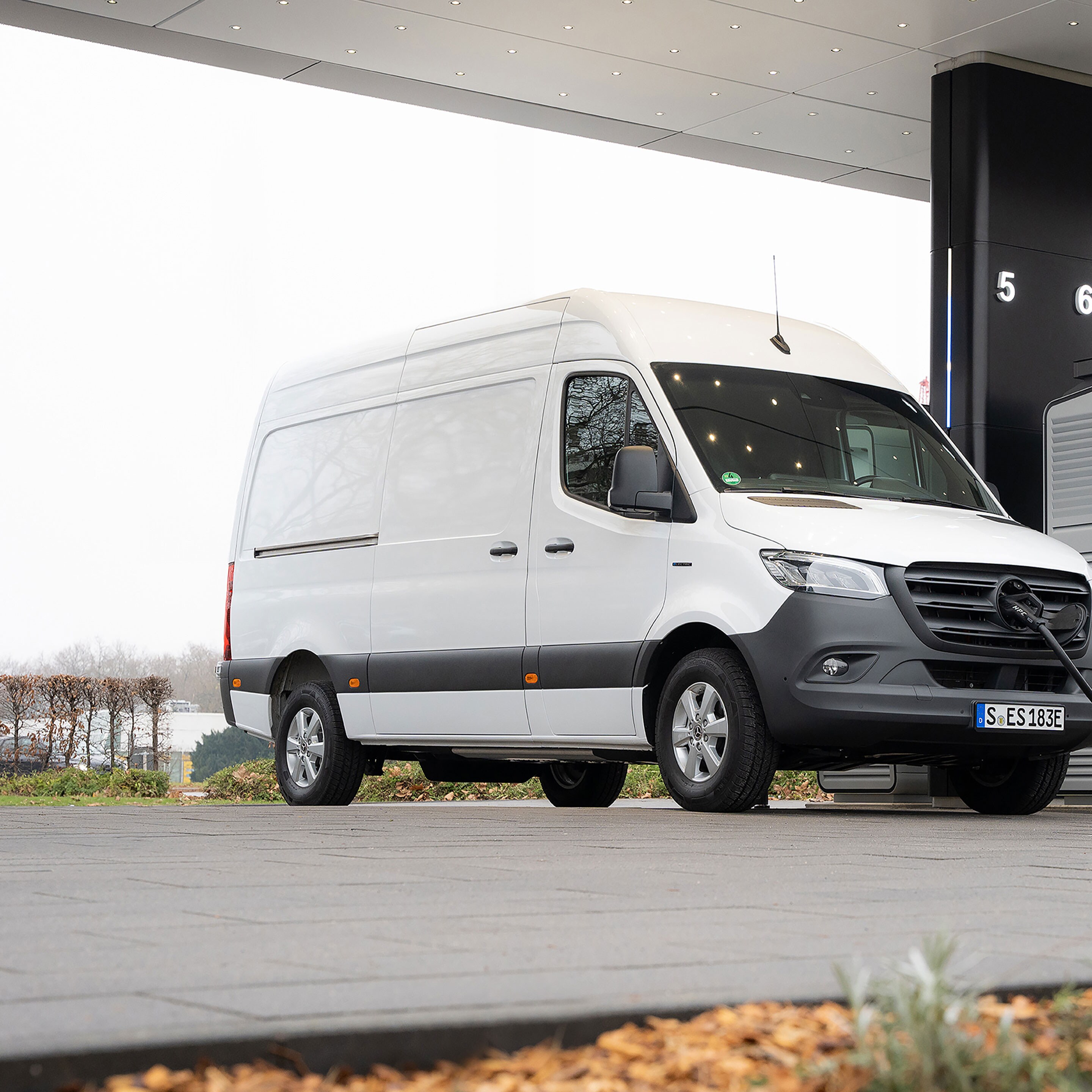 Un veicolo commerciale Mercedes-Benz davanti a una stazione di ricarica durante la ricarica.