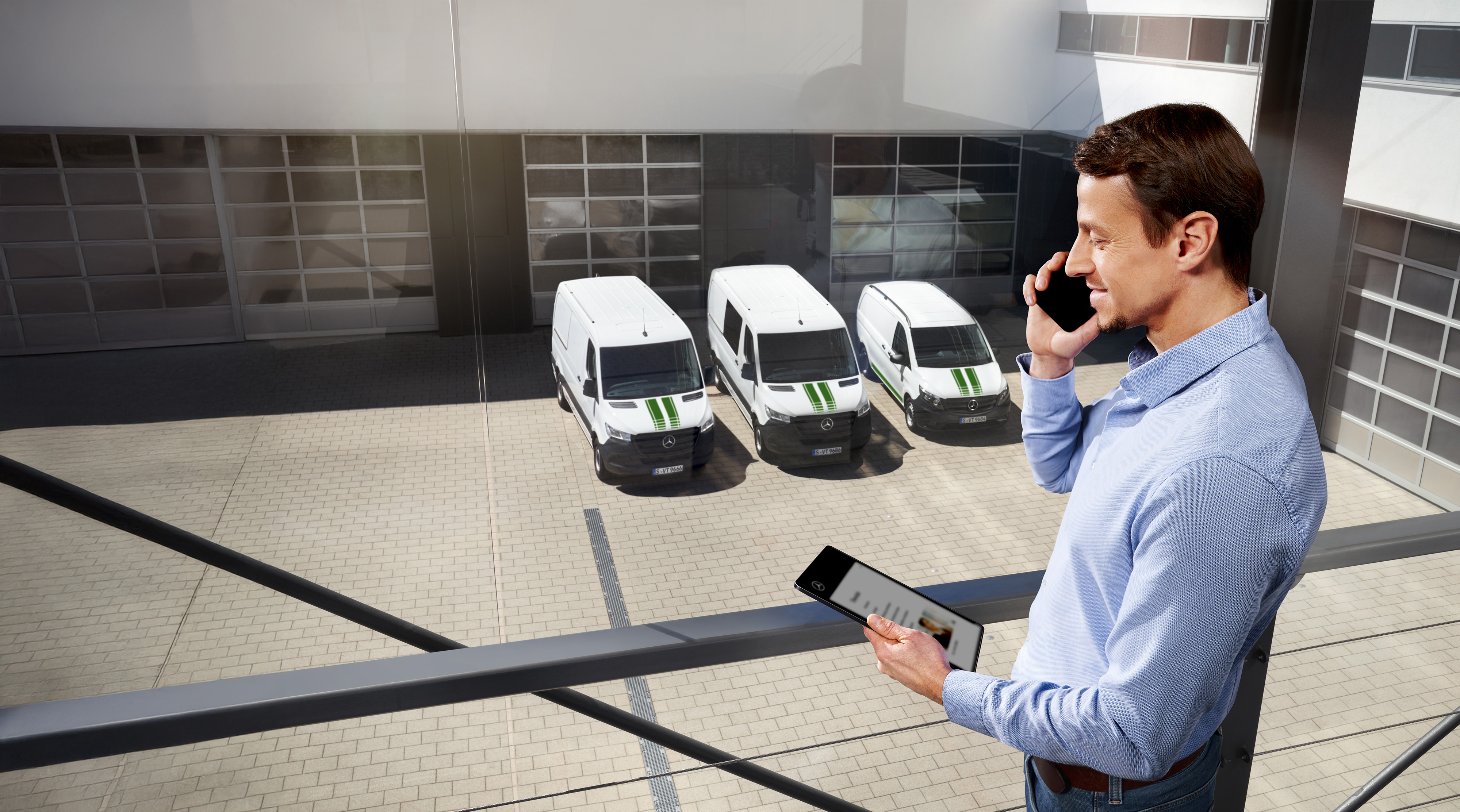 Mercedes-Benz | Garanzia commerciale della qualità dei veicoli commerciali Un uomo al telefono con un tablet davanti a tre veicoli commerciali Mercedes-Benz