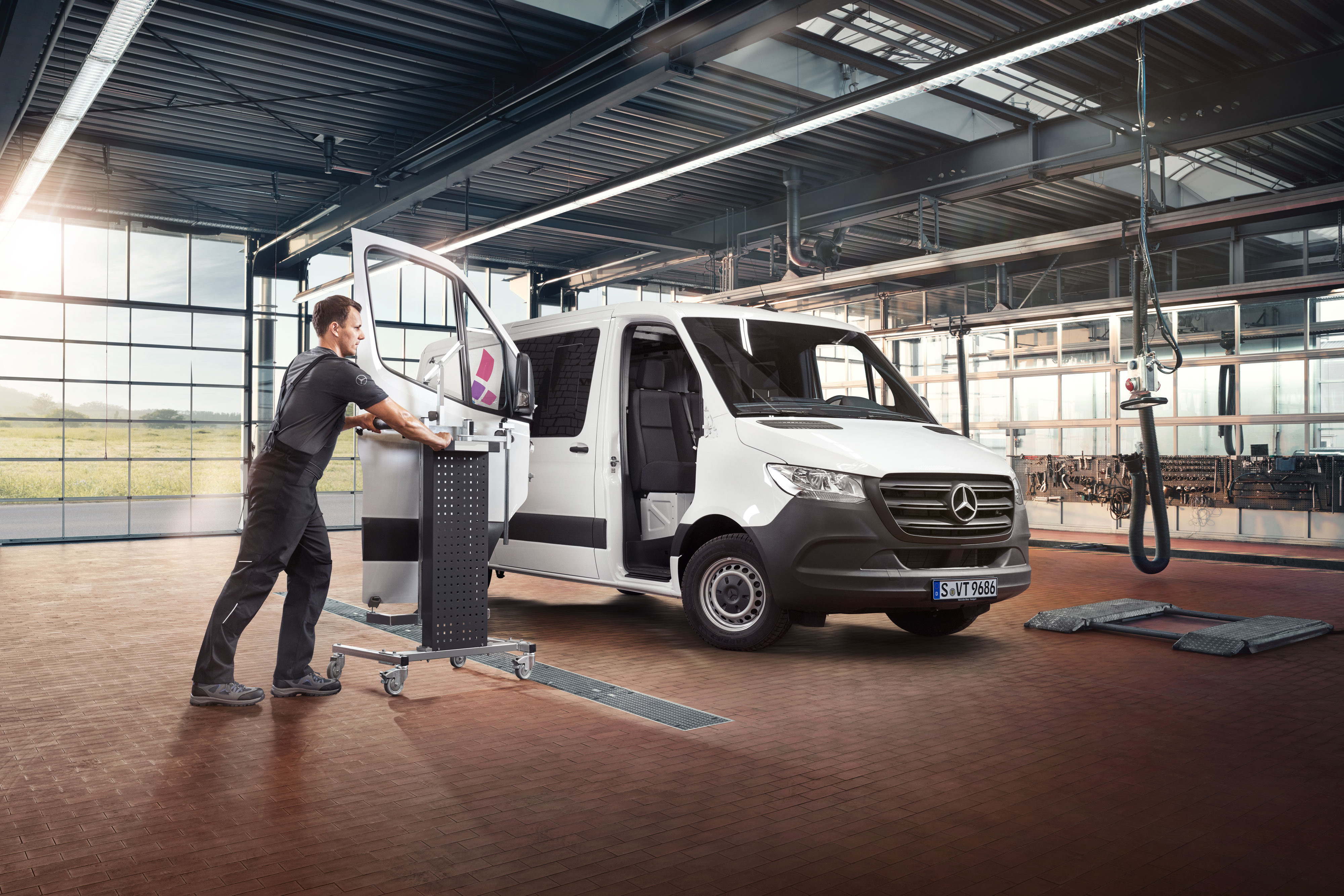 Mercedes-Benz | Quality Engineering per i veicoli commerciali Uno specialista Mercedes in una moderna officina mentre utilizza il tool Mercedes-Benz Xentry e attrezzi speciali per operare su un veicolo commerciale.