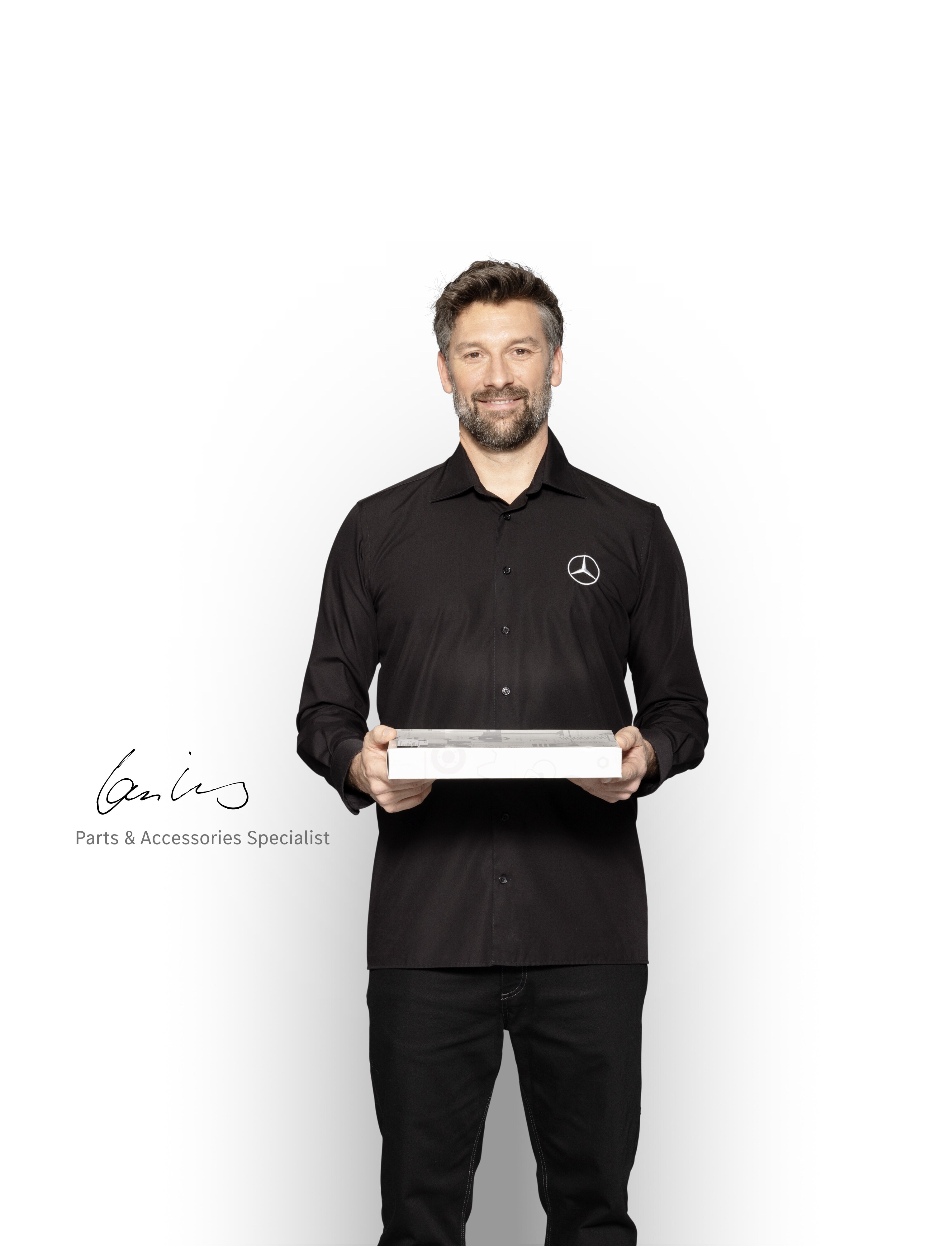 Uno specialista dei ricambi con un tablet pronto a fornire informazioni sugli standard di qualità Mercedes-Benz