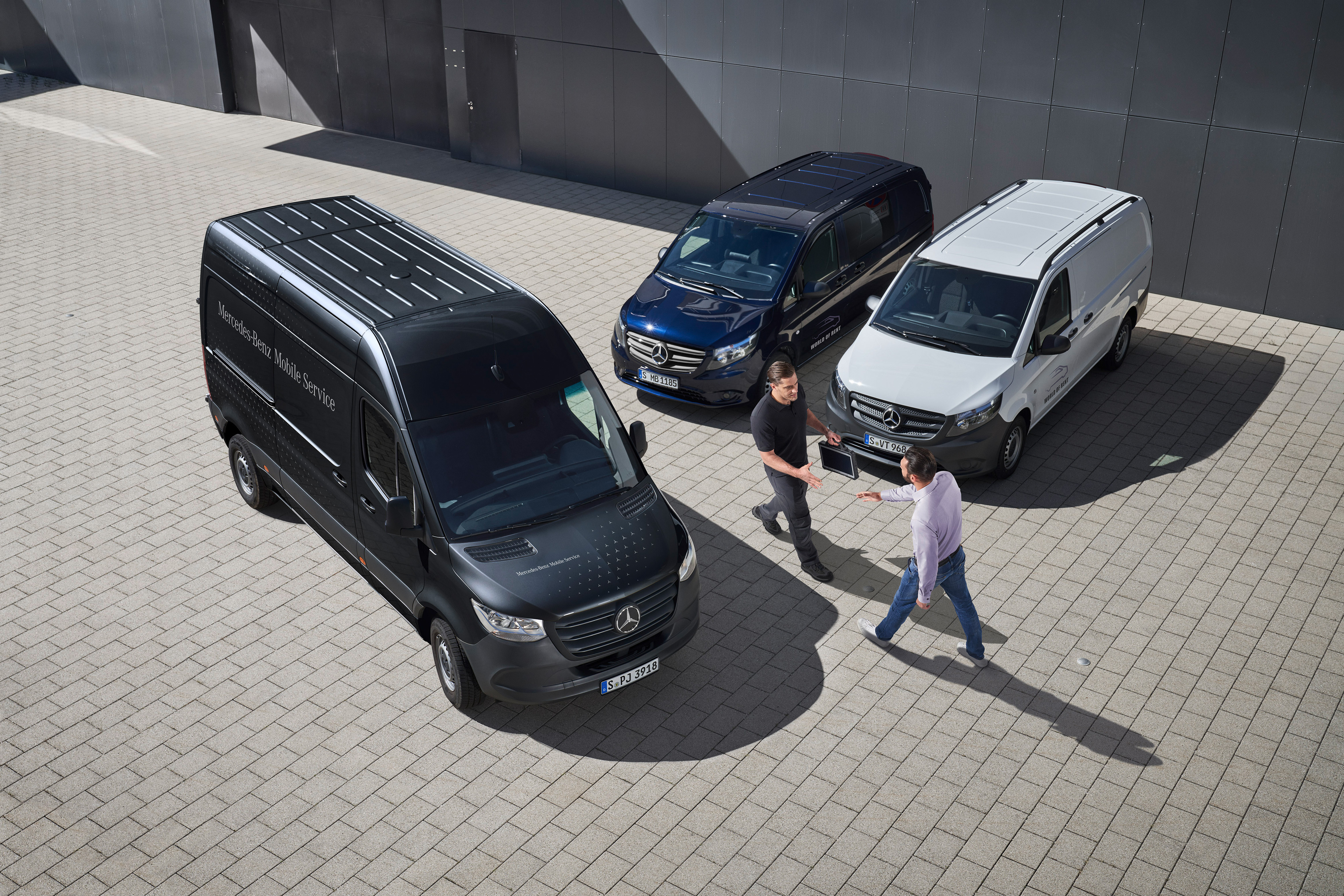 Mercedes-Benz | Panoramica dei servizi | Mobile Service Due uomini si salutano tra alcuni veicoli commerciali Mercedes-Benz.