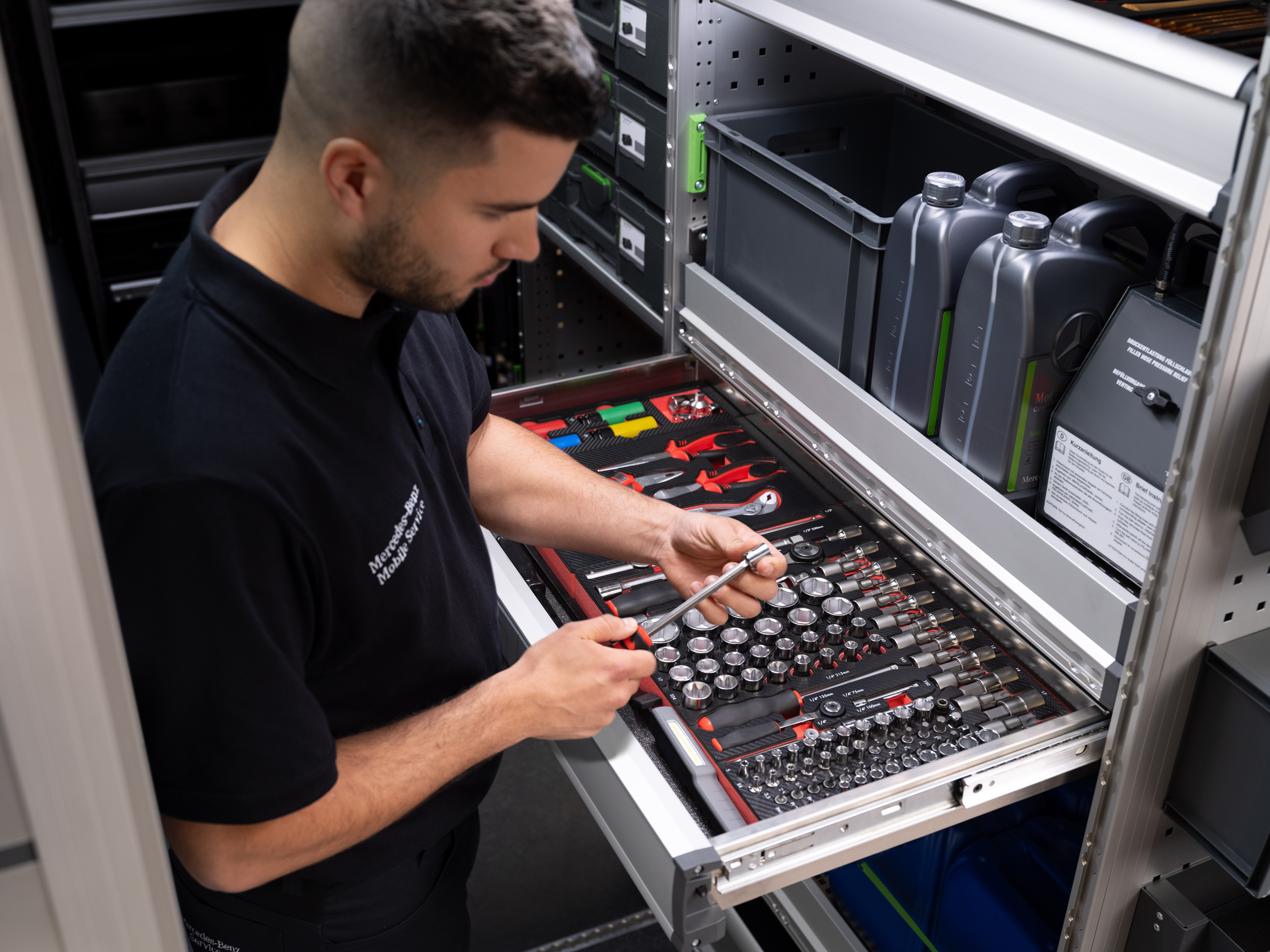 Mercedes-Benz | Mobile Service | Elettronica Un tecnico preleva un oggetto da un cassetto pieno di attrezzi.