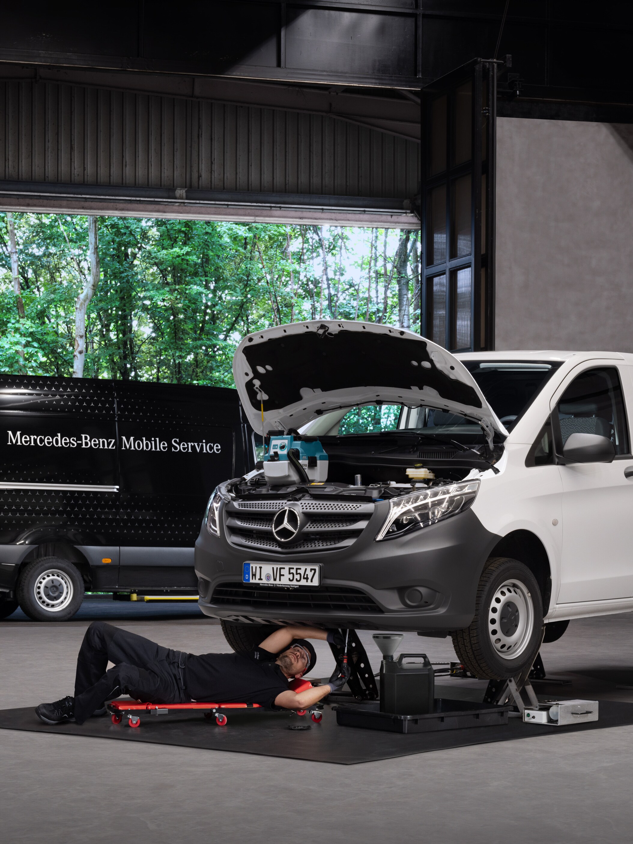 Un tecnico ripara un veicolo commerciale Mercedes-Benz Vito bianco.